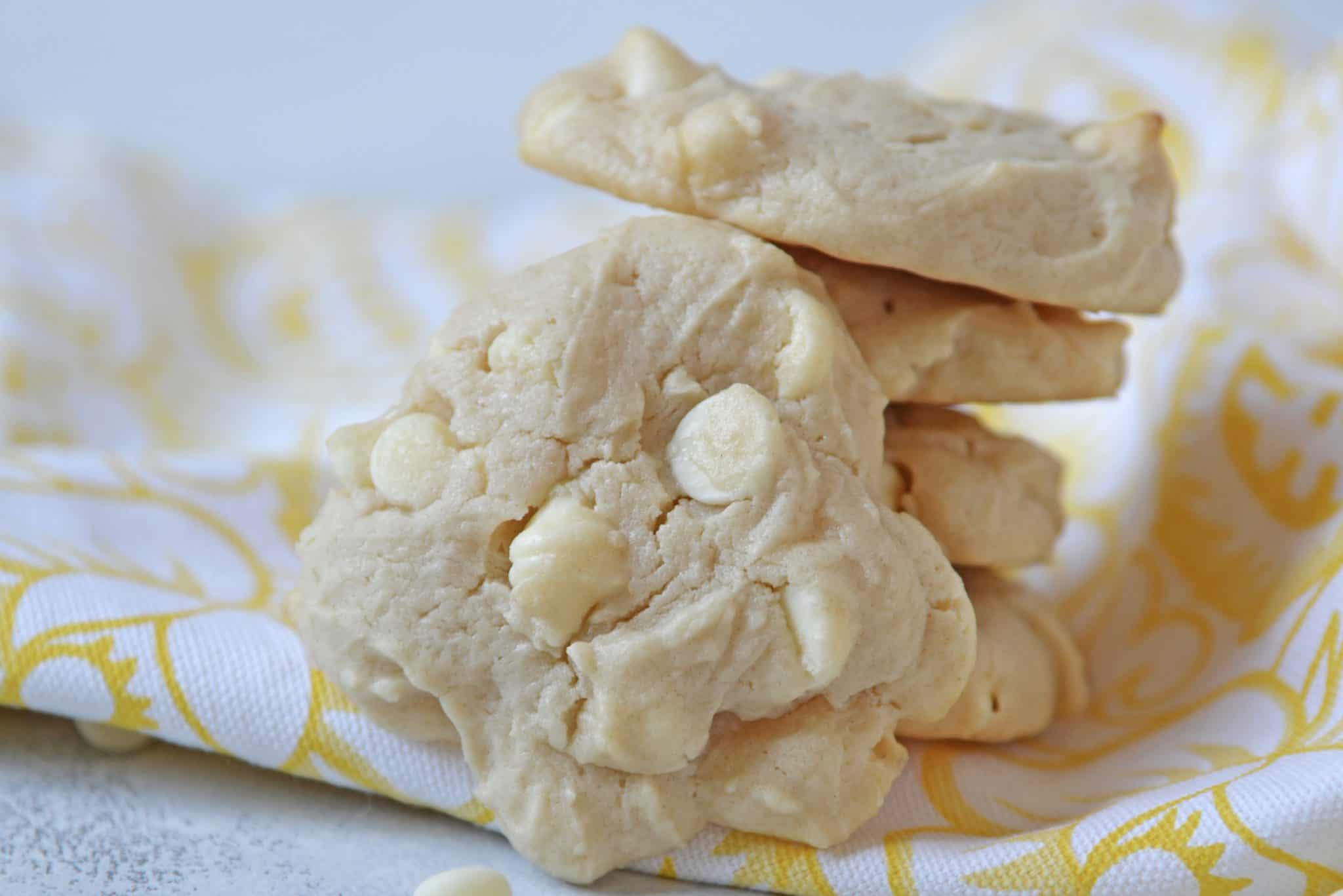 These Lemon White Chocolate Chip Cookies are a cross between a chocolate chip cookie & a lemon sugar cookie! A perfectly fluffy & mouth watering combination! #lemoncookierecipe #lemoncookies #whitechocolatechipcookies www.savoryexperiments.com