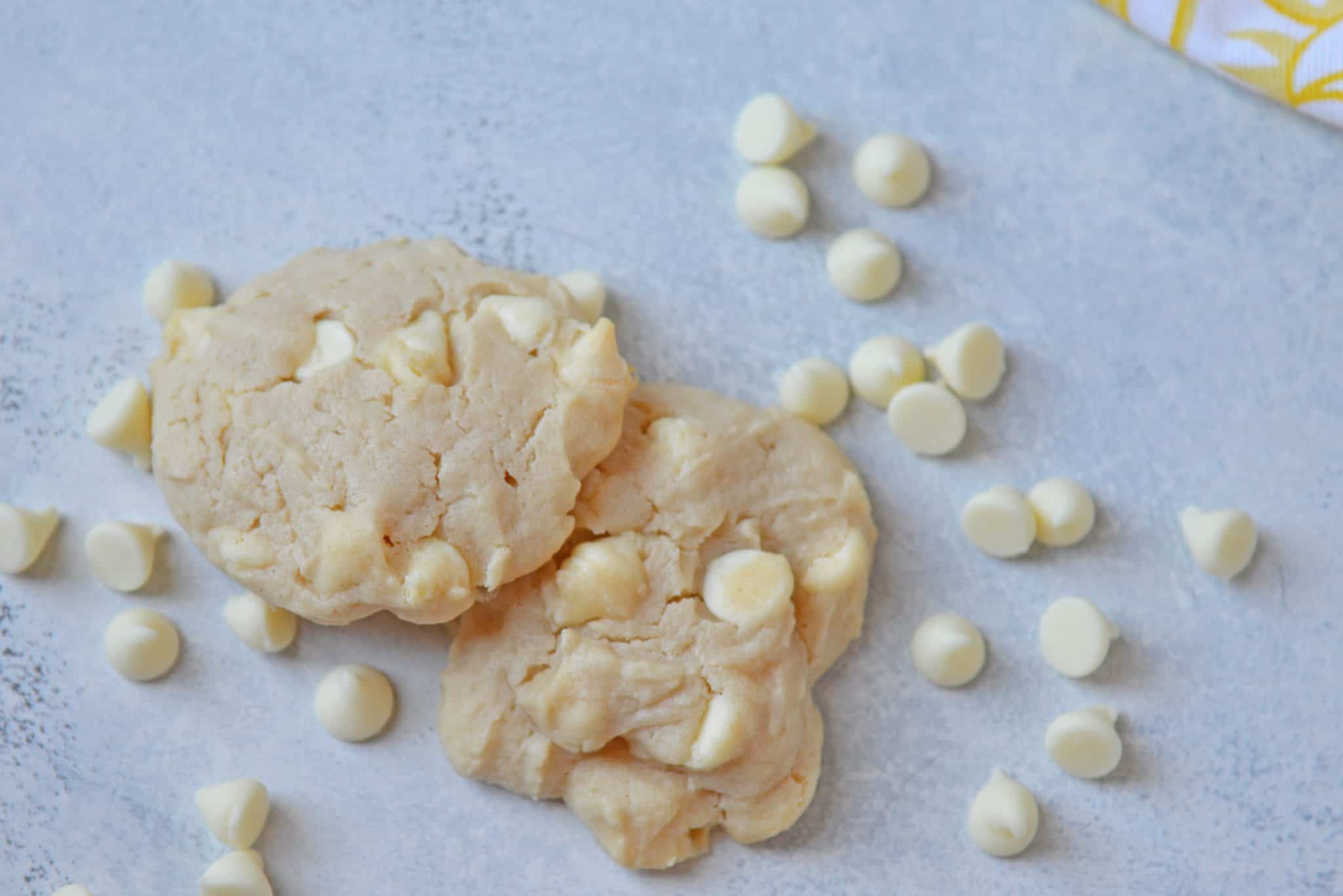 These Lemon White Chocolate Chip Cookies are a cross between a chocolate chip cookie & a lemon sugar cookie! A perfectly fluffy & mouth watering combination! #lemoncookierecipe #lemoncookies #whitechocolatechipcookies www.savoryexperiments.com