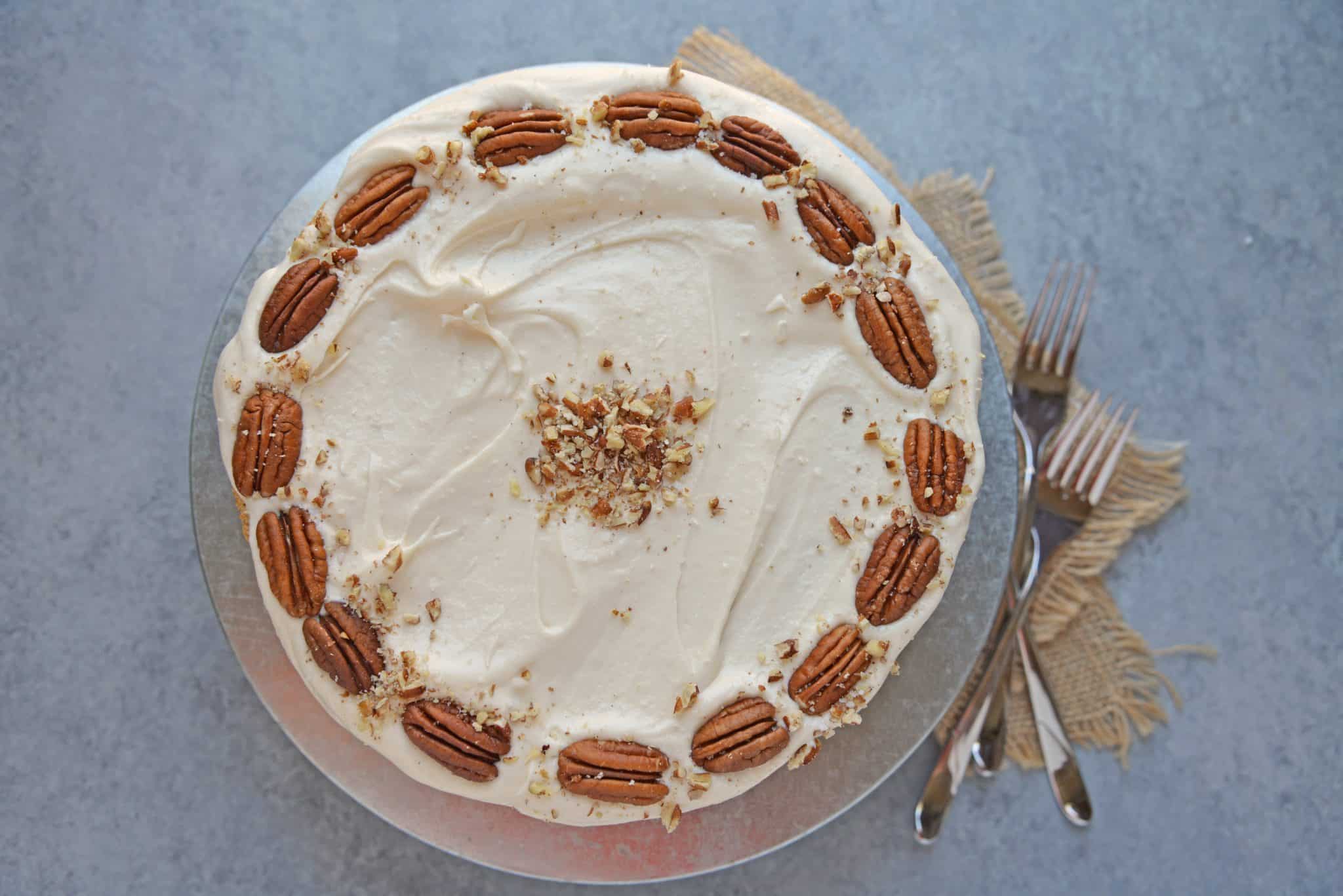 Brown Butter Caramel Cake is a two layer naked cake made with toffee bits and salted caramel frosting! The perfect summer cake or show stopping centerpiece. #caramelcake #brownbuttercake #nakedcakes www.savoryexperiments.com