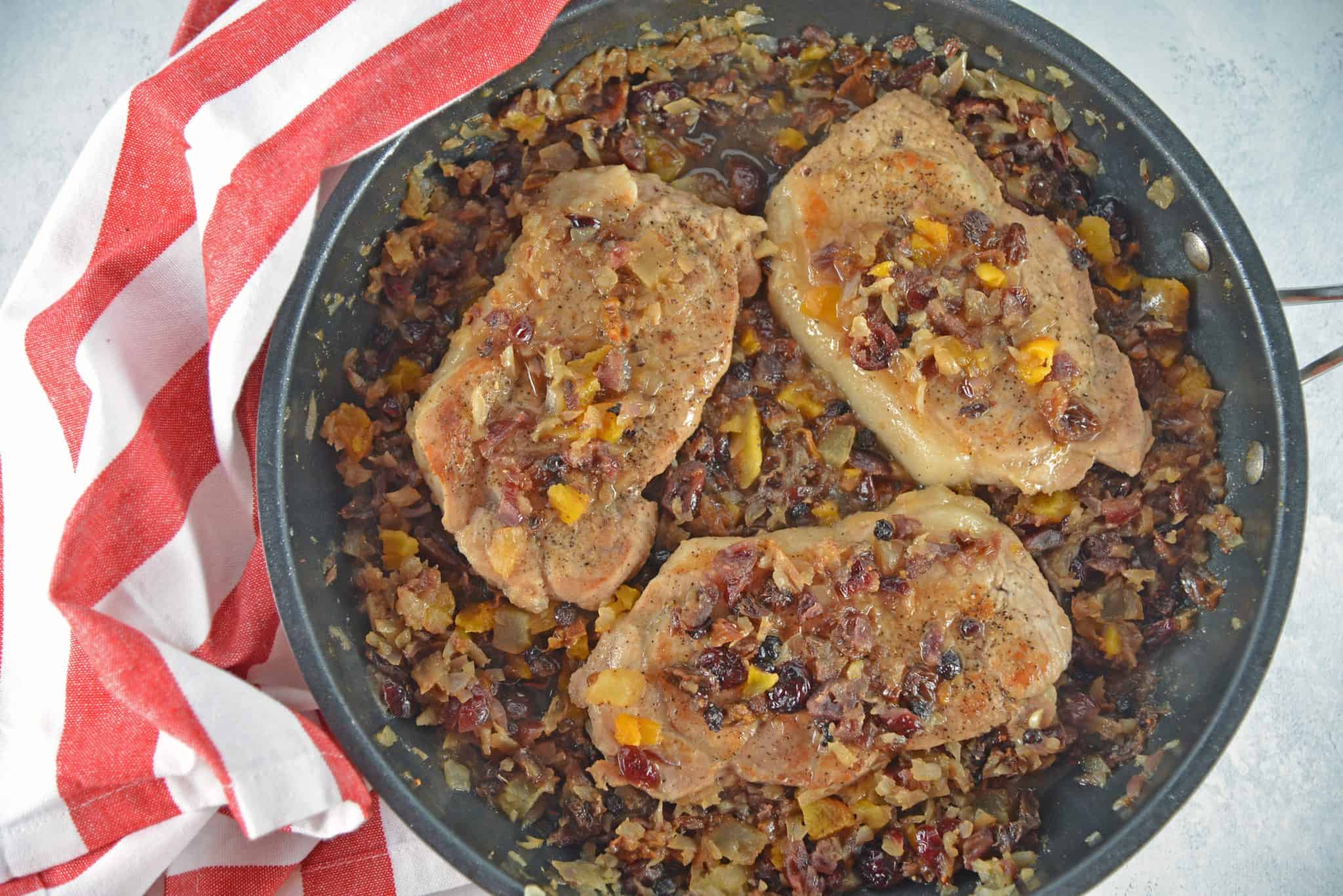 Fruit Smothered Pork Chops are pan fried pork chops with a zesty dried fruit sauce, taking 30 minutes from start to finish! #fruitsmotheredporkchops #panfriedporkchops www.savoryexperiments.com