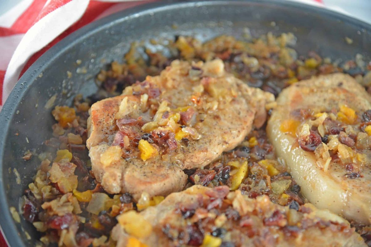 Fruit Smothered Pork Chops are pan fried pork chops with a zesty dried fruit sauce, taking 30 minutes from start to finish! #fruitsmotheredporkchops #panfriedporkchops www.savoryexperiments.com