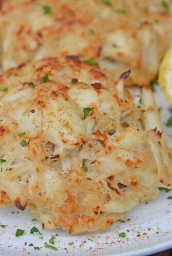 Close up of Maryland Crab Cakes on a white plate with lemons
