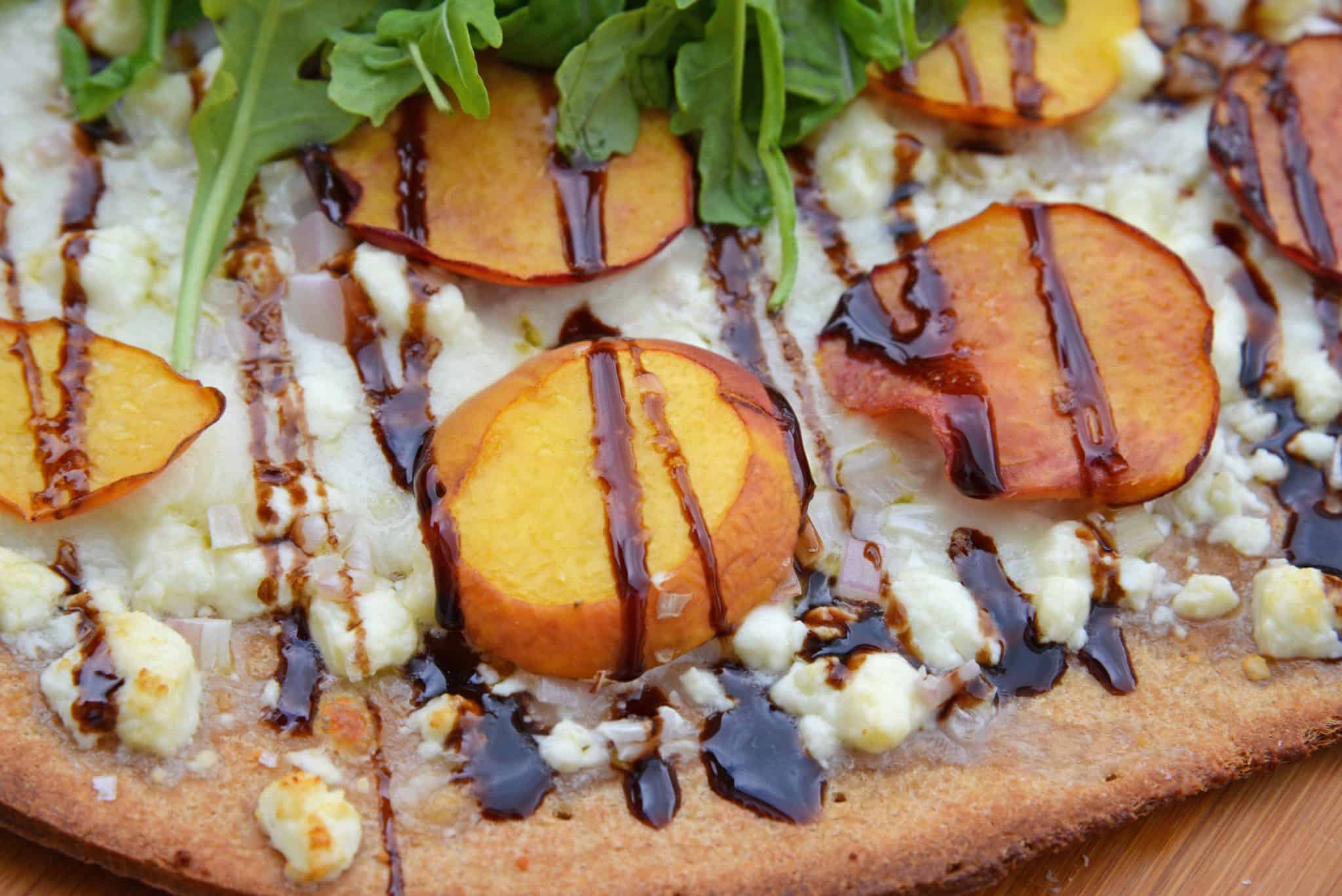 Peach Pizza is a delicious pizza variation that uses fresh peaches, melty mozzarella and gorgonzola cheeses and a sweet balsamic reduction sauce. The best homemade pizza recipe! #homemadepizzarecipe www.savoryexperiments.com