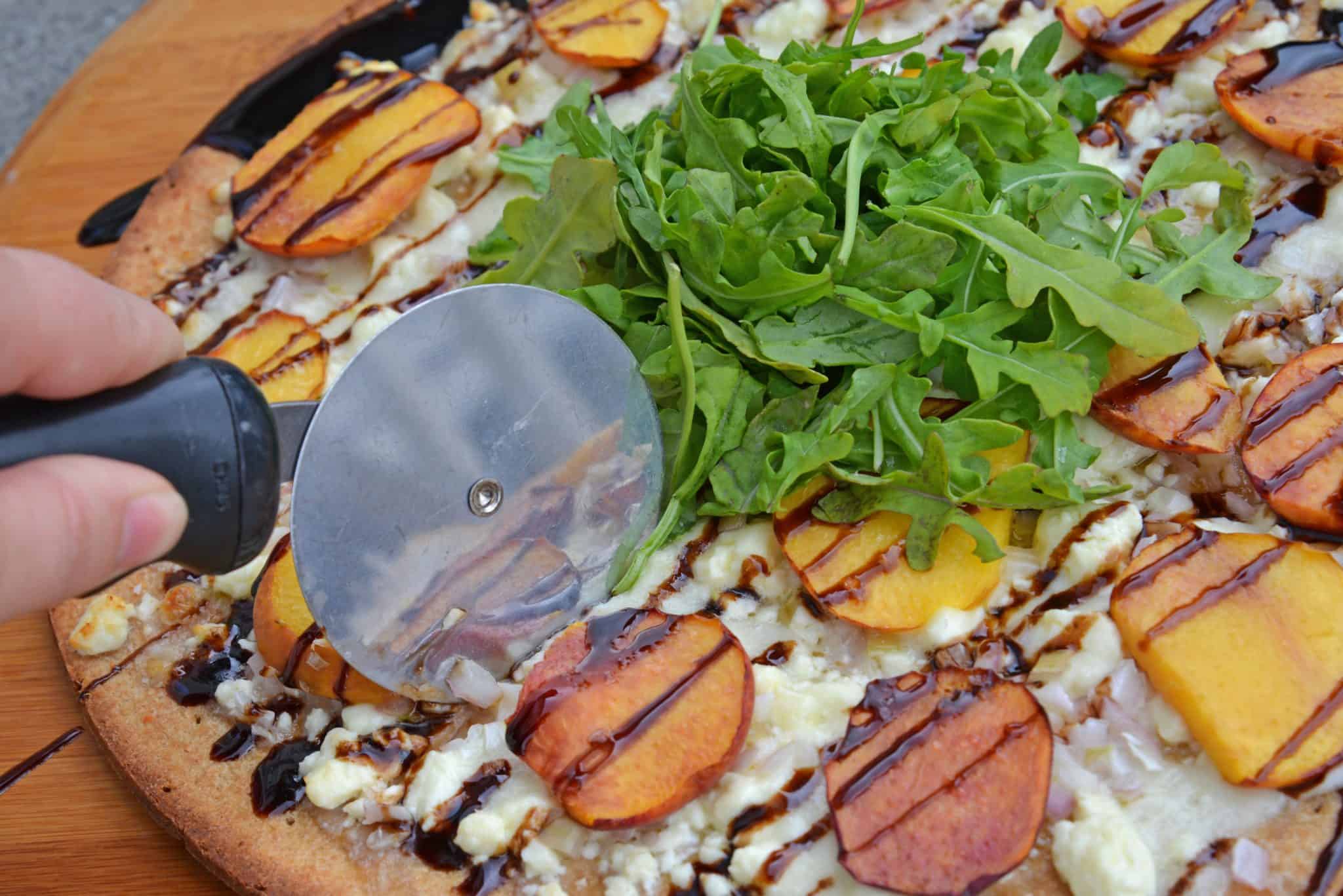 Peach Pizza is a delicious pizza variation that uses fresh peaches, melty mozzarella and gorgonzola cheeses and a sweet balsamic reduction sauce. The best homemade pizza recipe! #homemadepizzarecipe www.savoryexperiments.com