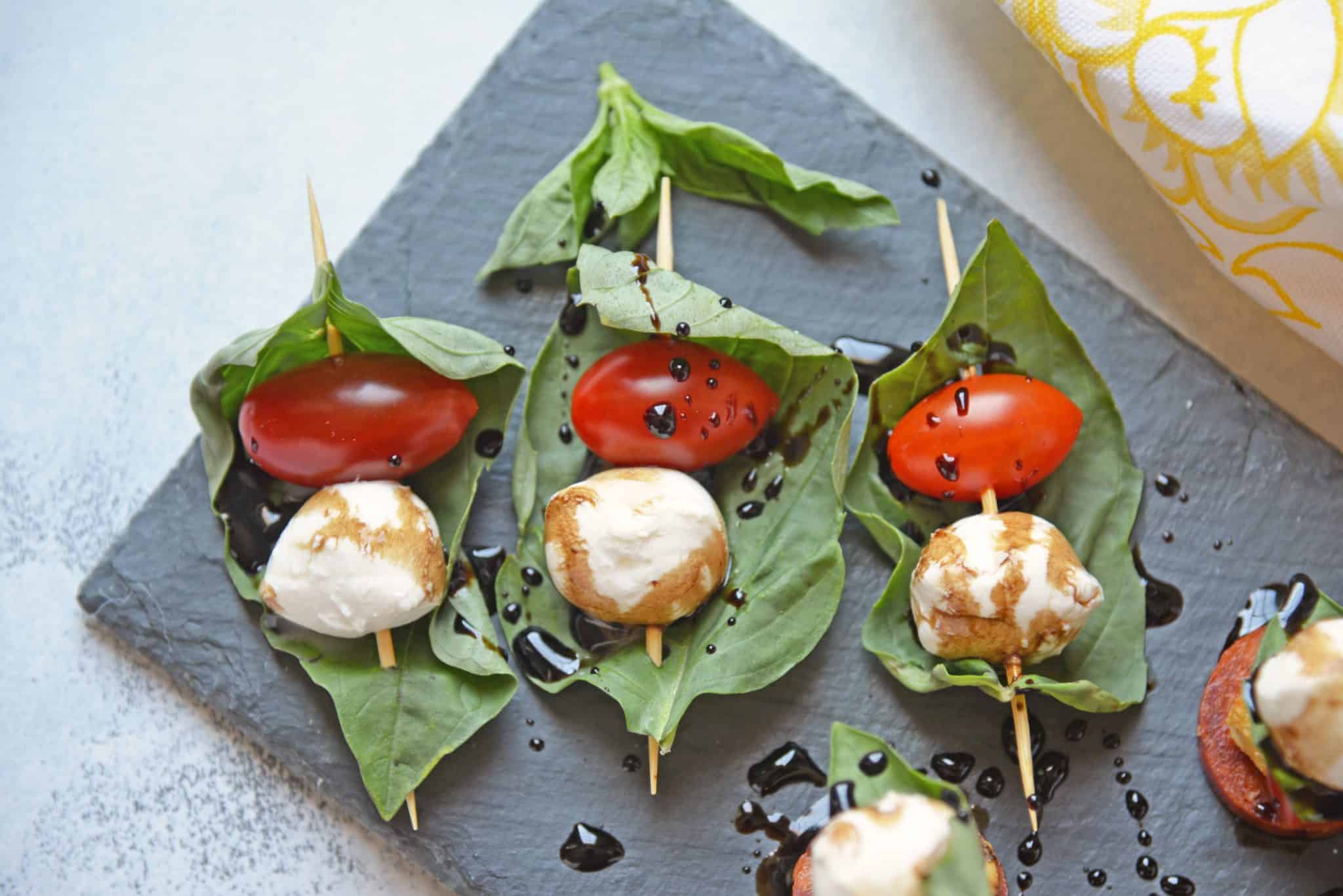 Caprese Skewers are the perfect party appetizer made with fresh mozzarella, basil, tomatoes, garlicky croutons, and zesty pepperoni, all drizzled with a tangy balsamic reduction sauce! #capresesalad #capreseappetizer www.savoryexperiments.com