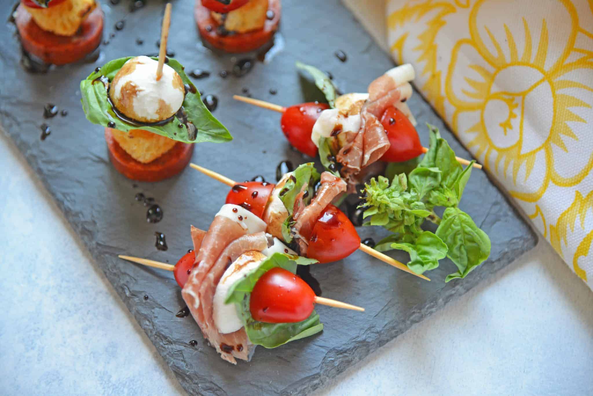 Caprese Skewers are the perfect party appetizer made with fresh mozzarella, basil, tomatoes, garlicky croutons, and zesty pepperoni, all drizzled with a tangy balsamic reduction sauce! #capresesalad #capreseappetizer www.savoryexperiments.com