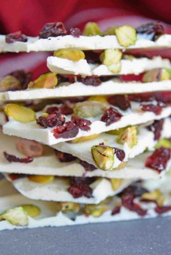 Pistachio Cranberry Bark is a delicious combination of pistachios, cranberries, and white chocolate! Perfect for the holiday season with its festive colors! #christmasbarkrecipe #pistachiocranberrybark www.savoryexperiments.com