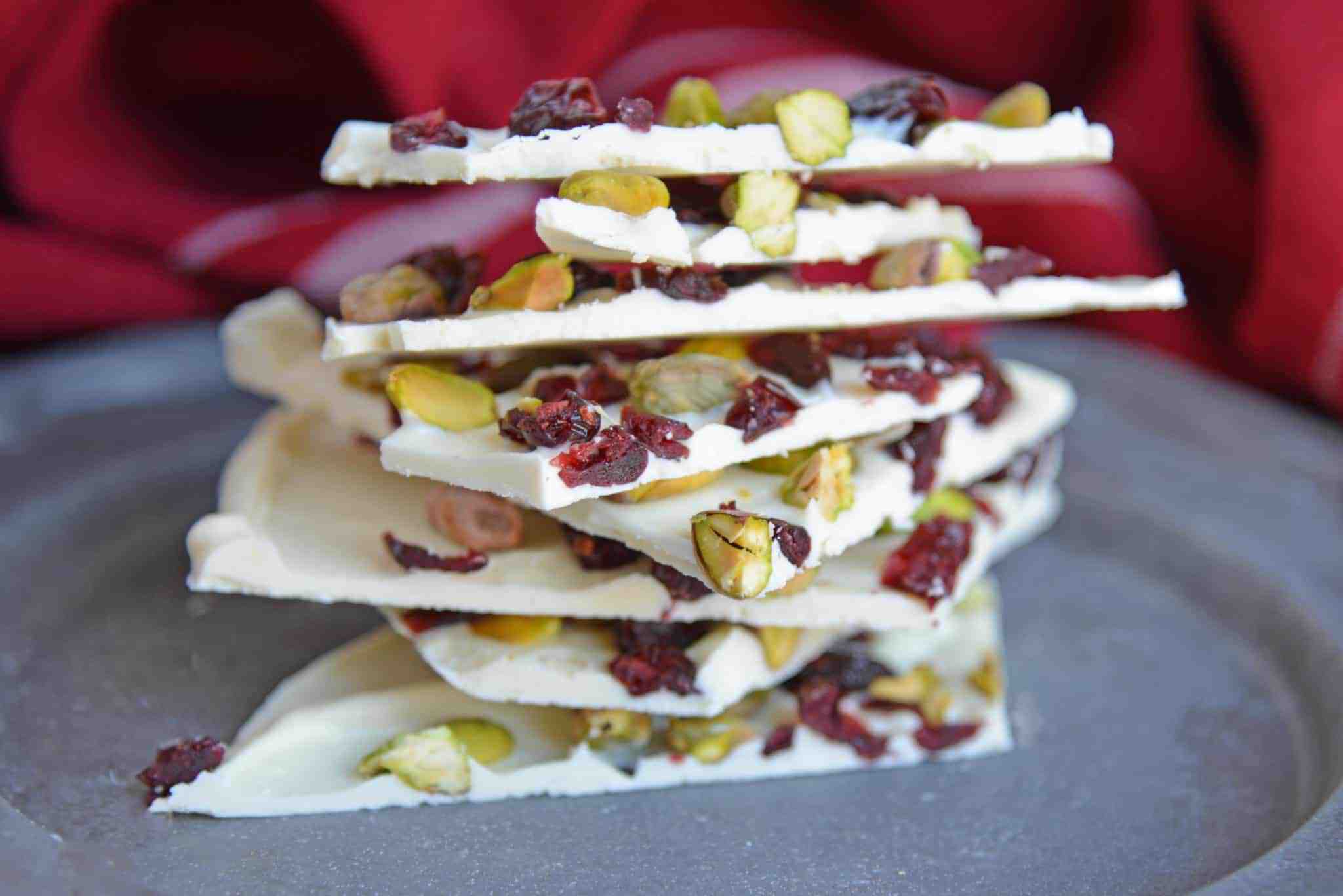 Pistachio Cranberry Bark is a delicious combination of pistachios, cranberries, and white chocolate! Perfect for the holiday season with its festive colors! #christmasbarkrecipe #pistachiocranberrybark www.savoryexperiments.com