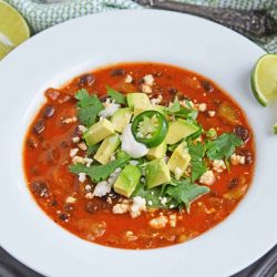Black bean green chile soup is a tomato based soup with smoky chipotle peppers and robust flavors. Top with avocado, cilantro and queso fresco! #easysoups #souprecipes www.savoryexperiments.com