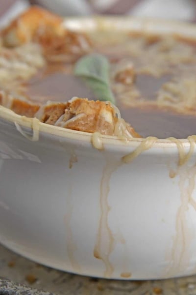 Apple French Onion Soup combines a robust French Onion Soup Recipe using sweet apples for flavor and texture. Top with crunchy garlic croutons and gooey cheese. #frenchonionsoup #fallsoup www.savoryexperiments.com