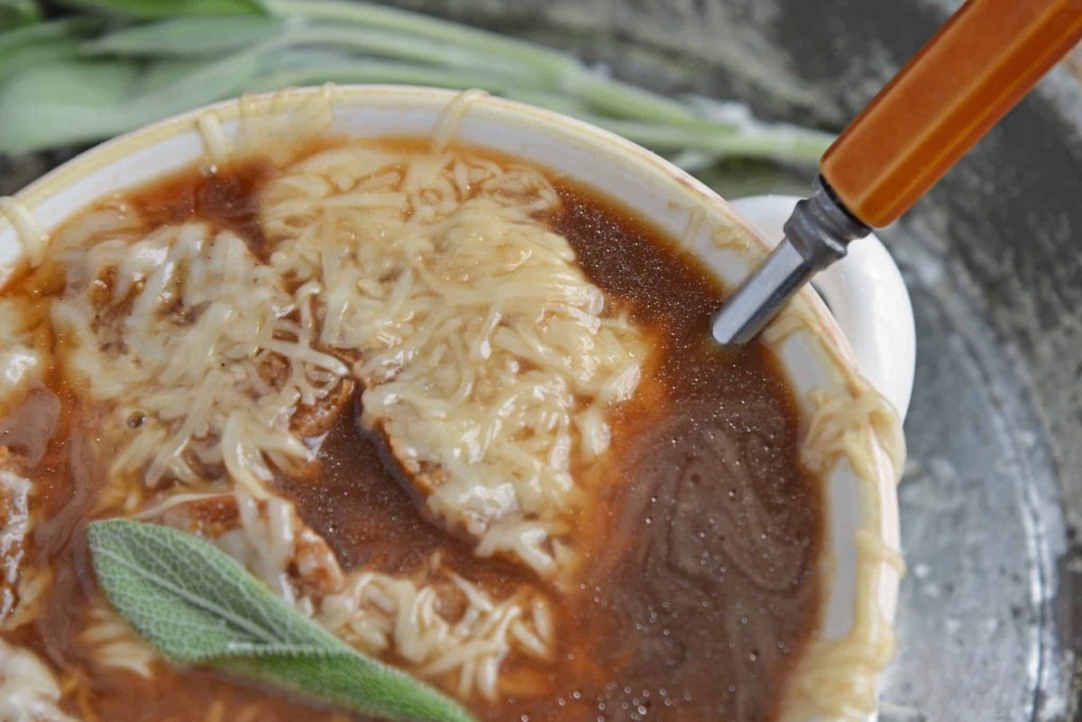 Apple French Onion Soup combines a robust French Onion Soup Recipe using sweet apples for flavor and texture. Top with crunchy garlic croutons and gooey cheese. #frenchonionsoup #fallsoup www.savoryexperiments.com