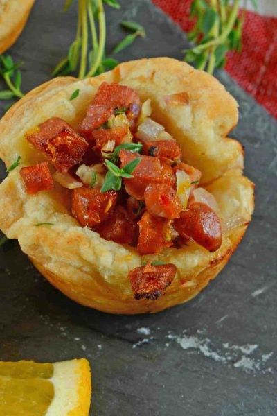 Citrus Sausage Cups are an easy appetizer using smoky andouille sausage, orange zest, sweet onion and fresh thyme in a puff pastry cup. #puffpastryappetizers #puffpastrycups www.savoryexperiments.com