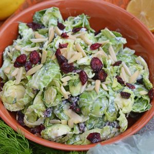 Cranberry Almond Brussel Sprout Slaw is a healthy and delicious way to eat raw brussels sprouts. Mixed with yogurt, dill, cranberry and almond, it is packed with flavor! #brusselsproutsrecipe #brusselsproutsalad www.savoryexperiments.com