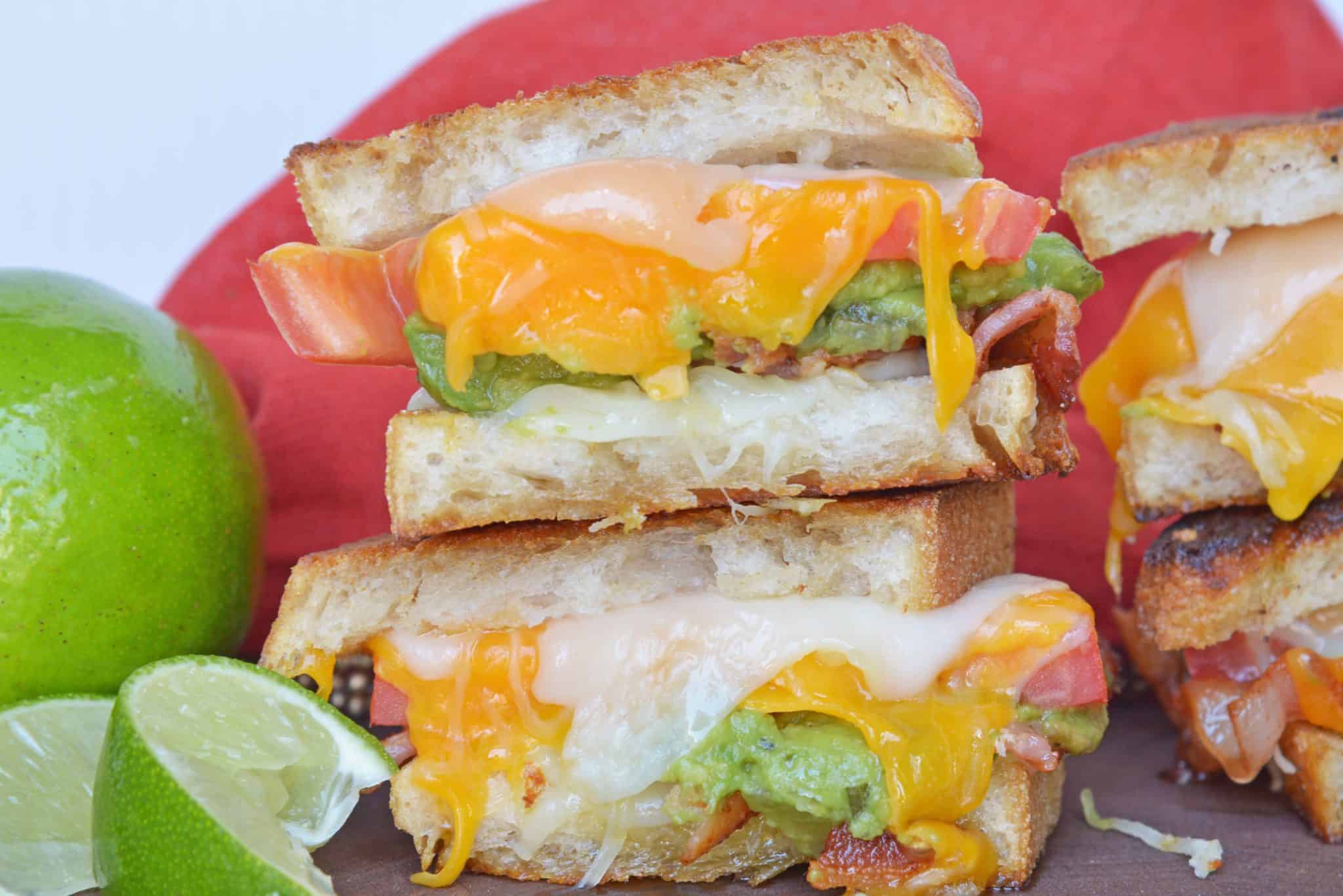 Bacon Avocado Grilled Cheese Sandwiches are made from a three cheese blend along with zesty guacamole, lime, and bacon, for out of this world sandwich experience! #howtomakegrilledcheese #gourmetgrilledcheese #avocadogrilledcheese www.savoryexperiments.com