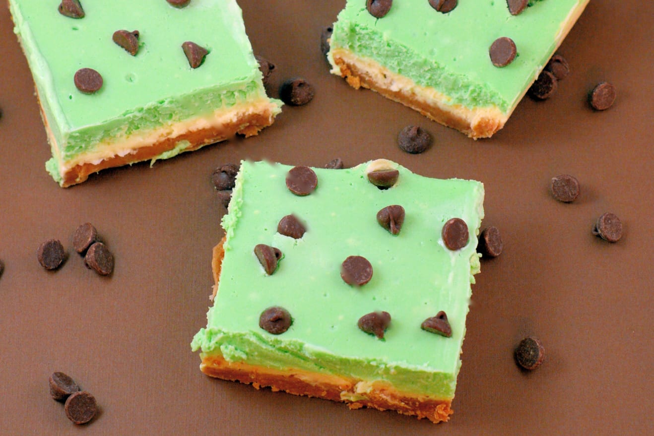 Grasshopper Cheesecake Bars are the perfect St Patrick's day dessert. Green and minty, they are easy to make and delicious to eat! #cheesecakebars #cheesecakebarsrecipe www.savoryexperiments.com