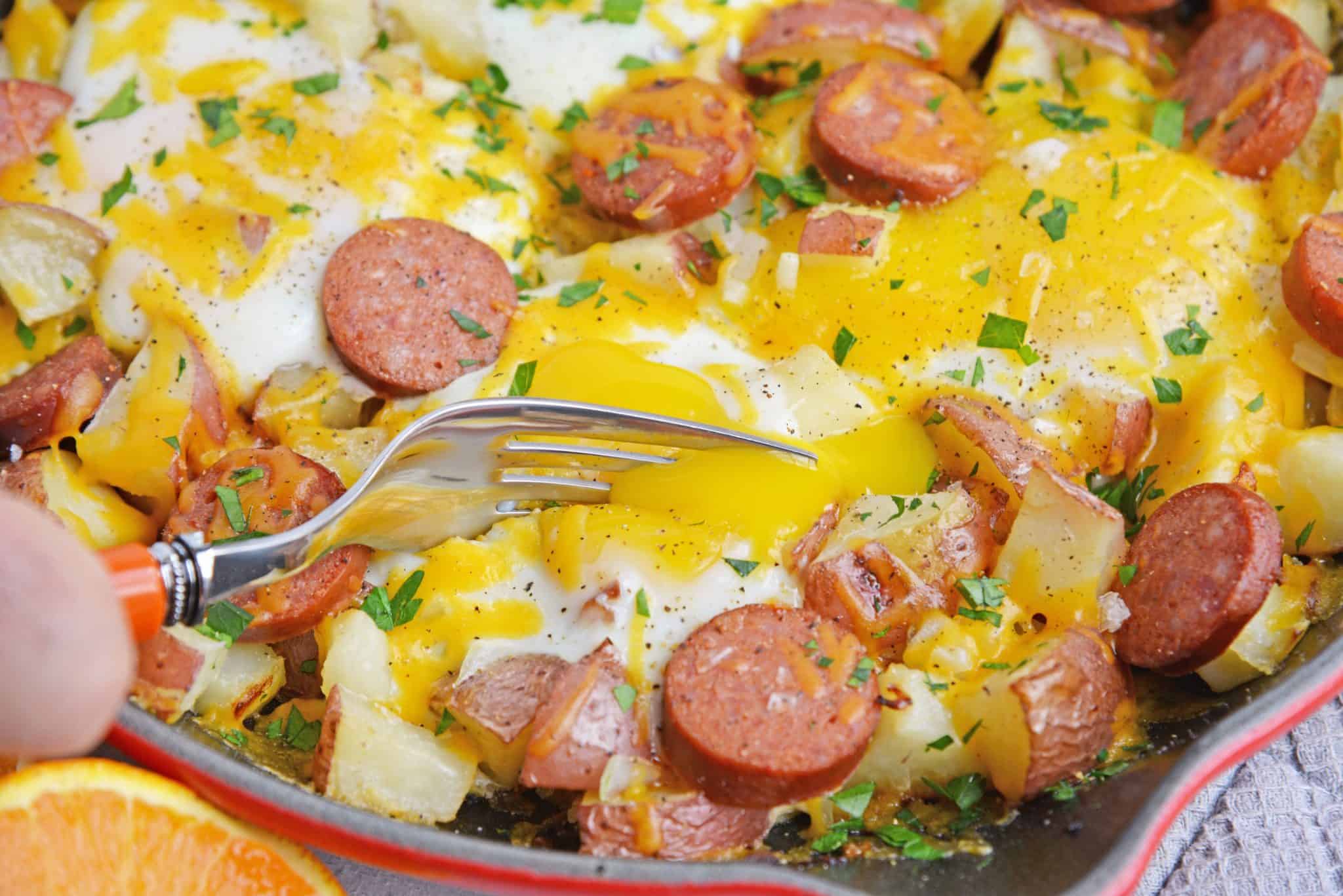 Sausage and Egg Skillet is a delicious breakfast skillet with andouille sausage, potato, eggs and gooey cheese. Ready in 30 minutes and perfect for special weekend brunch! #breakfastskilletrecipe #castironskilletrecipes www.savoryexperiments.com