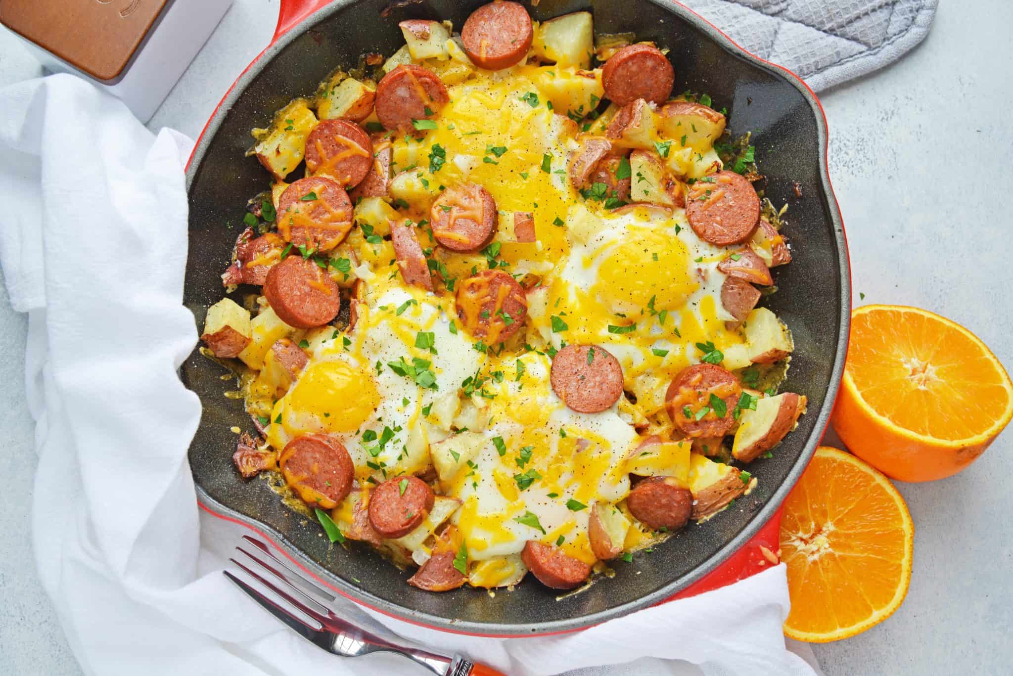 Sausage and Egg Skillet is a delicious breakfast skillet with andouille sausage, potato, eggs and gooey cheese. Ready in 30 minutes and perfect for special weekend brunch! #breakfastskilletrecipe #castironskilletrecipes www.savoryexperiments.com