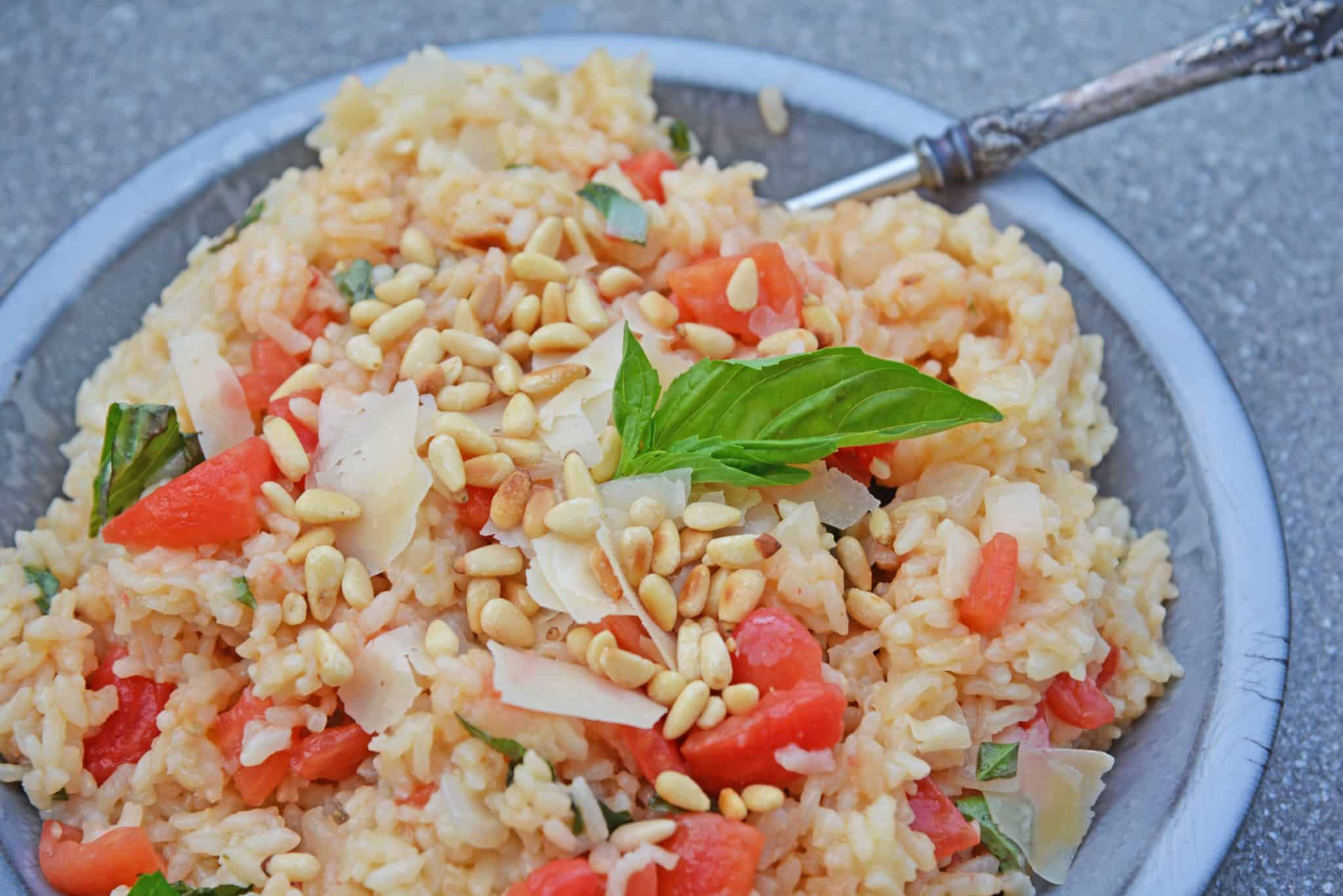 Tomato Parmesan Risotto is a creamy and delicious Italian style risotto recipe. Made with tomatoes, basil, garlic, pine nuts, and parmesan cheese! #risottorecipe #howtocookrisotto #parmesanrisotto www.savoryexperiments.com