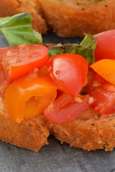 This Tomato Bruschetta recipe is a classic no cook appetizer that can be ready in as little as 20 minutes using fresh tomatoes, basil and garlic. #easybruschetta #tomatobruschetta www.savoryexperiments.com