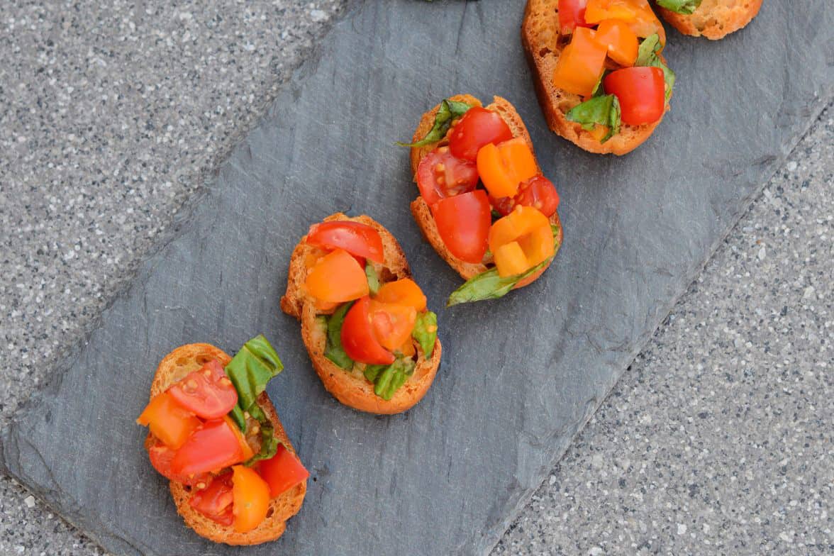 This Tomato Bruschetta recipe is a classic no cook appetizer that can be ready in as little as 20 minutes using fresh tomatoes, basil and garlic. #easybruschetta #tomatobruschetta www.savoryexperiments.com