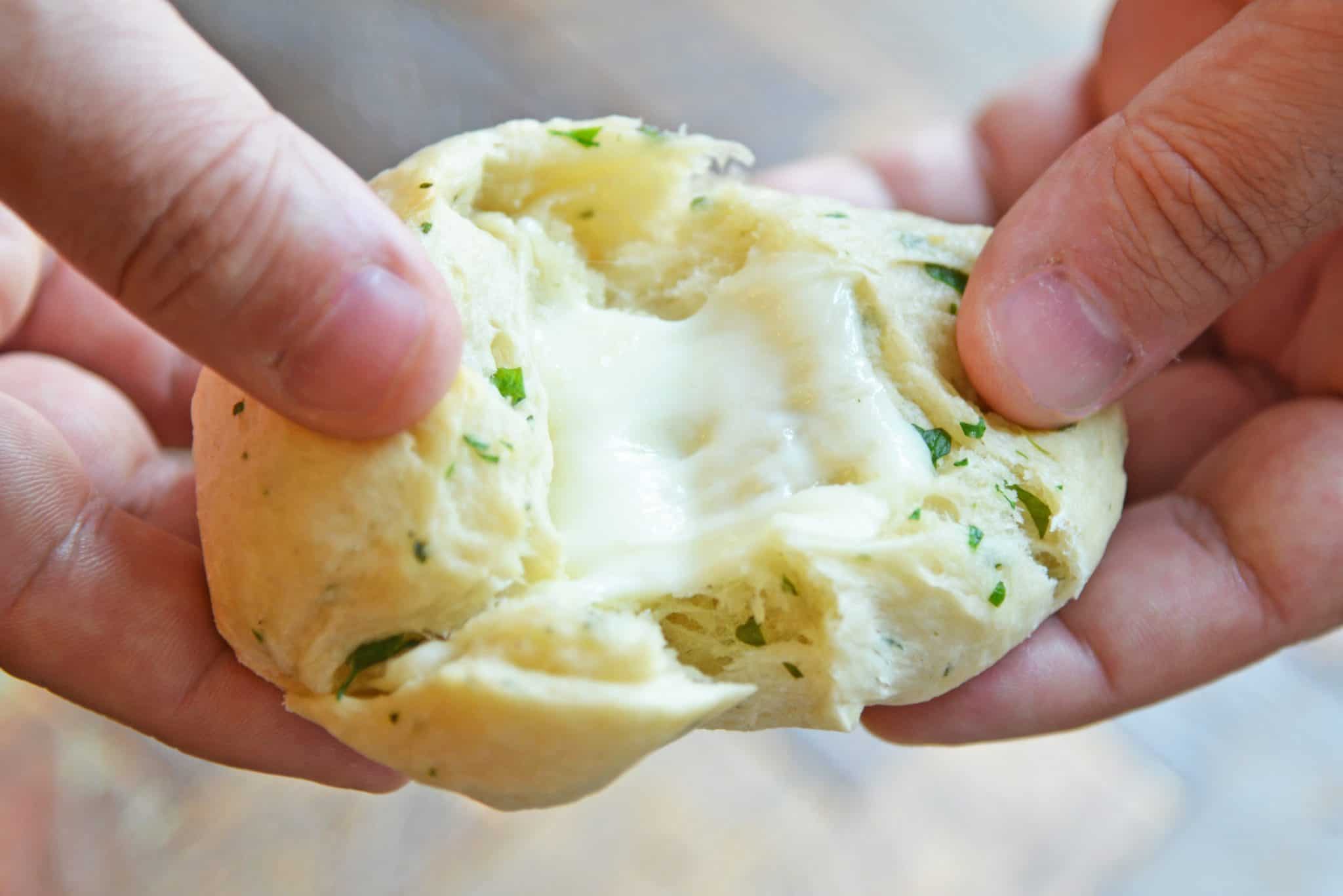 These Cheese Stuffed Garlic Rolls are delicious garlic and parsley rolls stuffed with gooey mozzarella cheese. Eat them plain or with a side of marinara. #cheesestuffedgarlicrolls #garlicrolls #mozzarella www.savoryexperiments.com