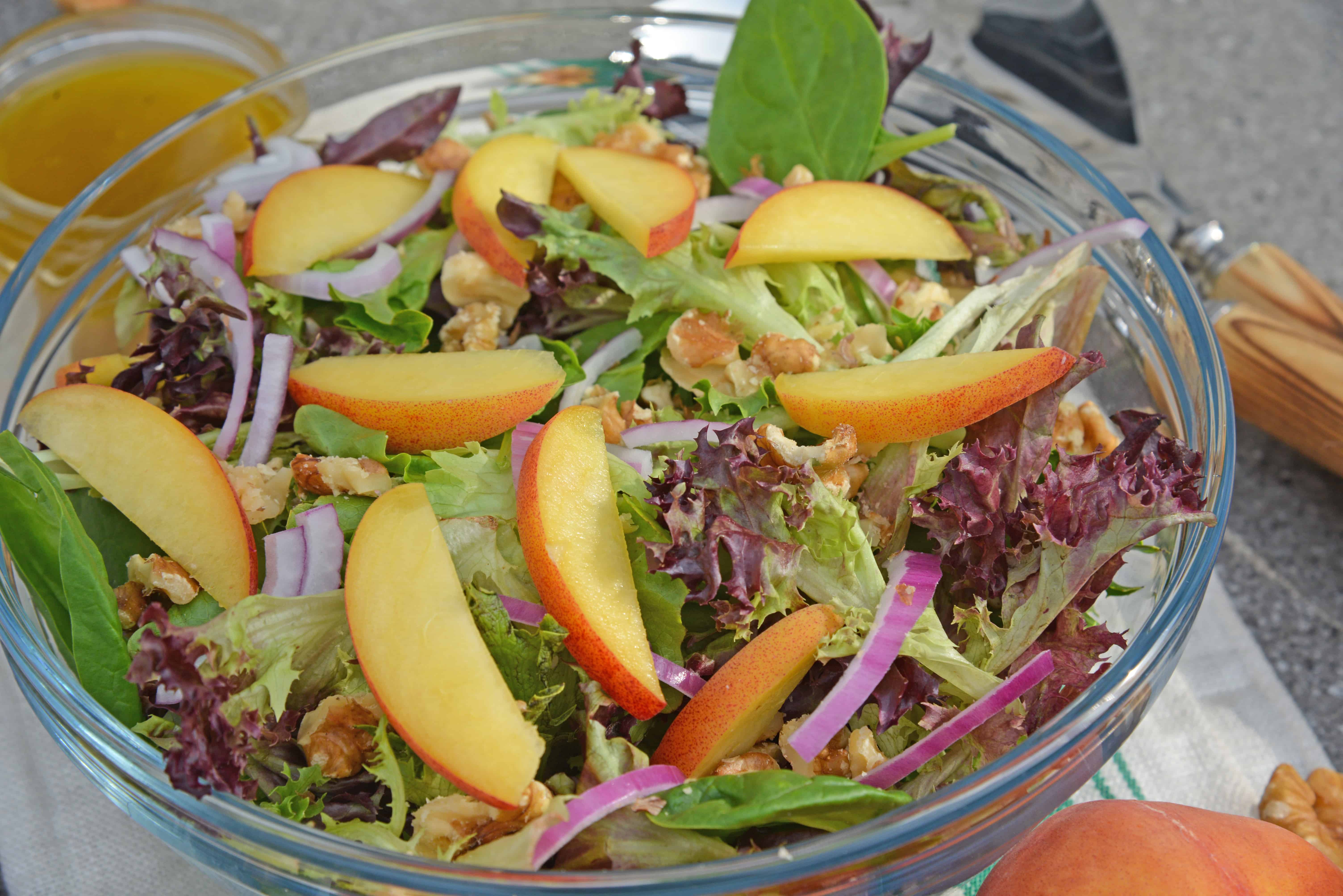 Peach Salad is a scrumptious summer salad filled with delicious peaches, gorgonzola cheese, shallots, candied walnuts and a tangy peach dressing. The perfect summer salad! #peachsalad #summersalads www.savoryexperiments.com