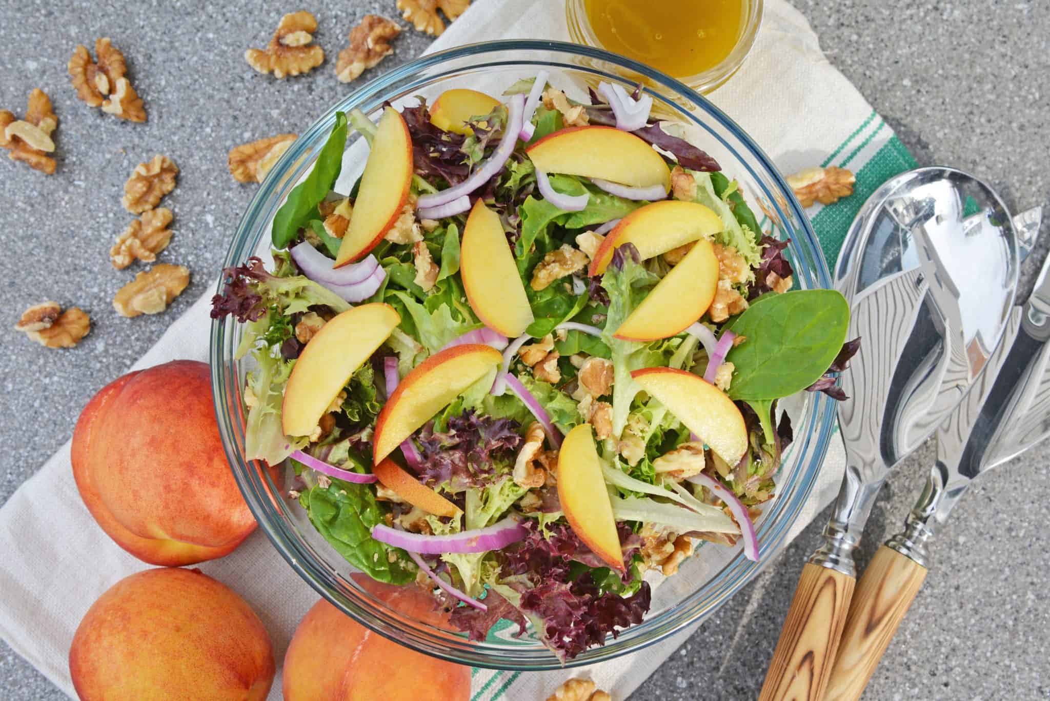 Peach Salad is a scrumptious summer salad filled with delicious peaches, gorgonzola cheese, shallots, candied walnuts and a tangy peach dressing. The perfect summer salad! #peachsalad #summersalads www.savoryexperiments.com