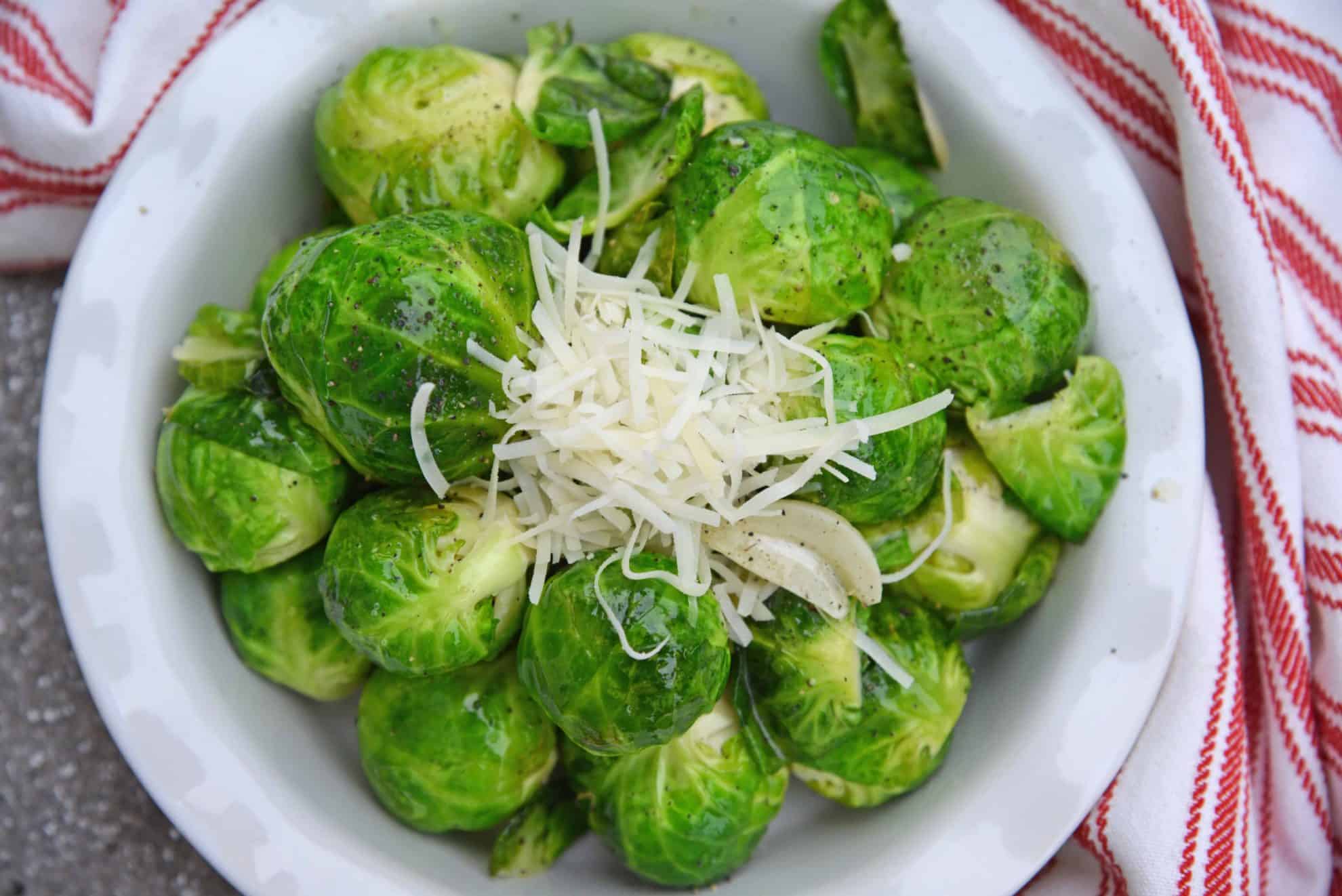 Garlic Butter Brussels Sprouts is an easy side dish that even sprout haters will love! Fresh brussel sprouts covered in butter, garlic, and topped with parmesan cheese. #brusselssproutsrecipes #garlicbutter www.savoryexperiments.com