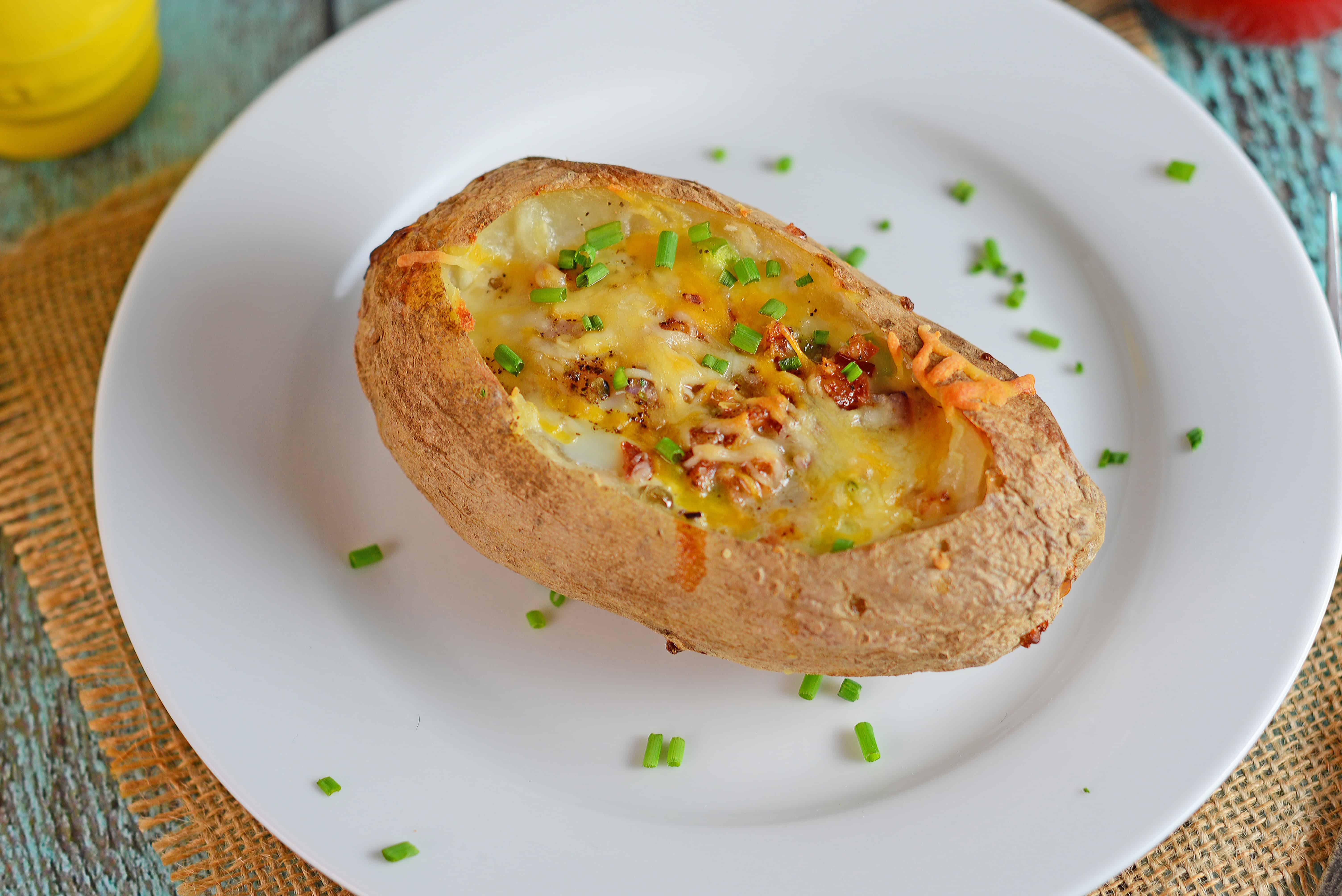 Stuffed Breakfast Potatoes are an easy one-dish breakfast solution perfect for feeding a group! Stuffed with cheese, your choice of veggies, bacon and an egg! #breakfastpotatoes #stuffedbakedpotatoes www.savoryexperiments.com