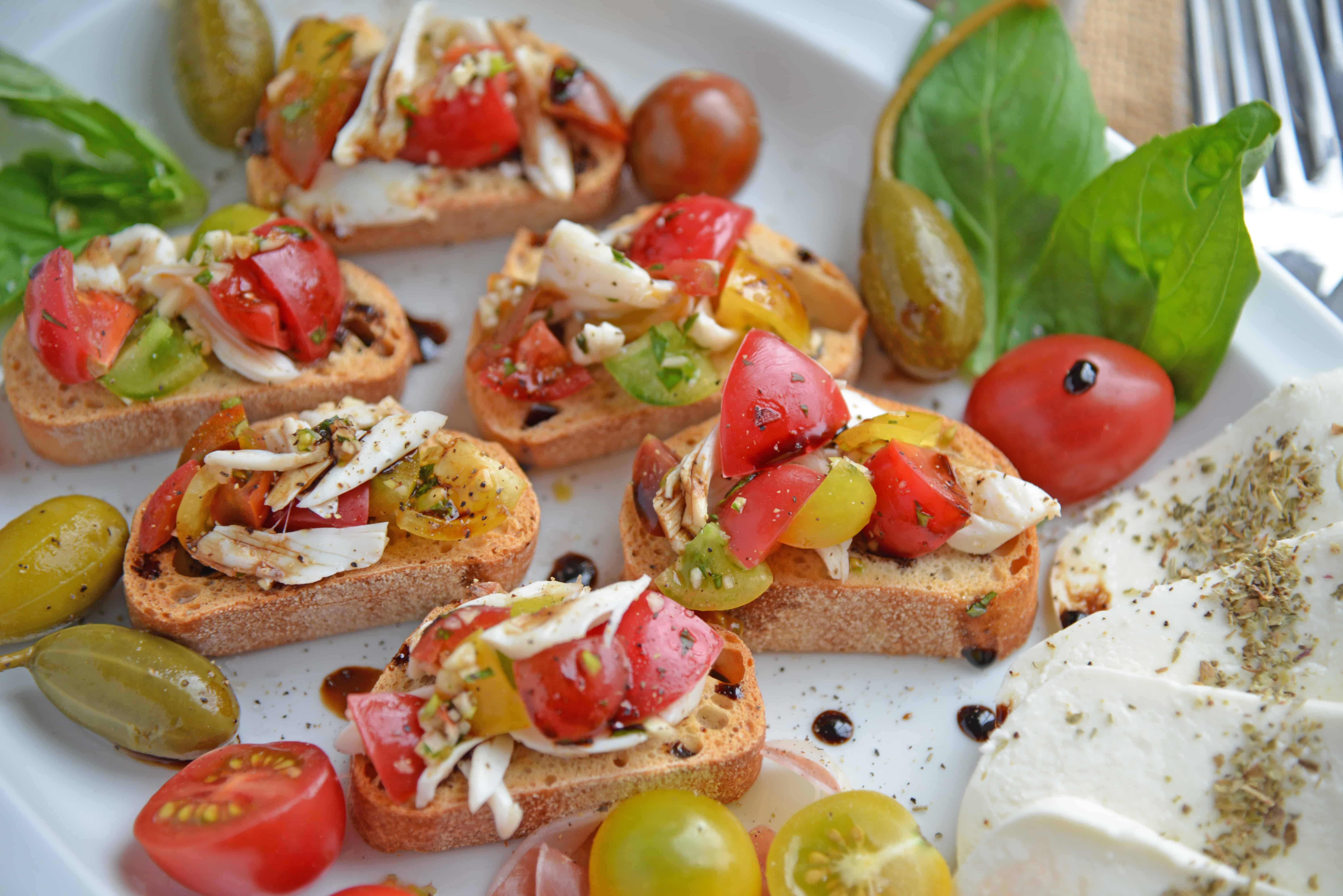 Crab Bruschetta is a mound of fresh tomatoes, garlic basil and buttery crab meat piled high on crispy toast. This is one of the best appetizers out there! #crabbruschetta #easybruschetta www.savoryexperiments.com