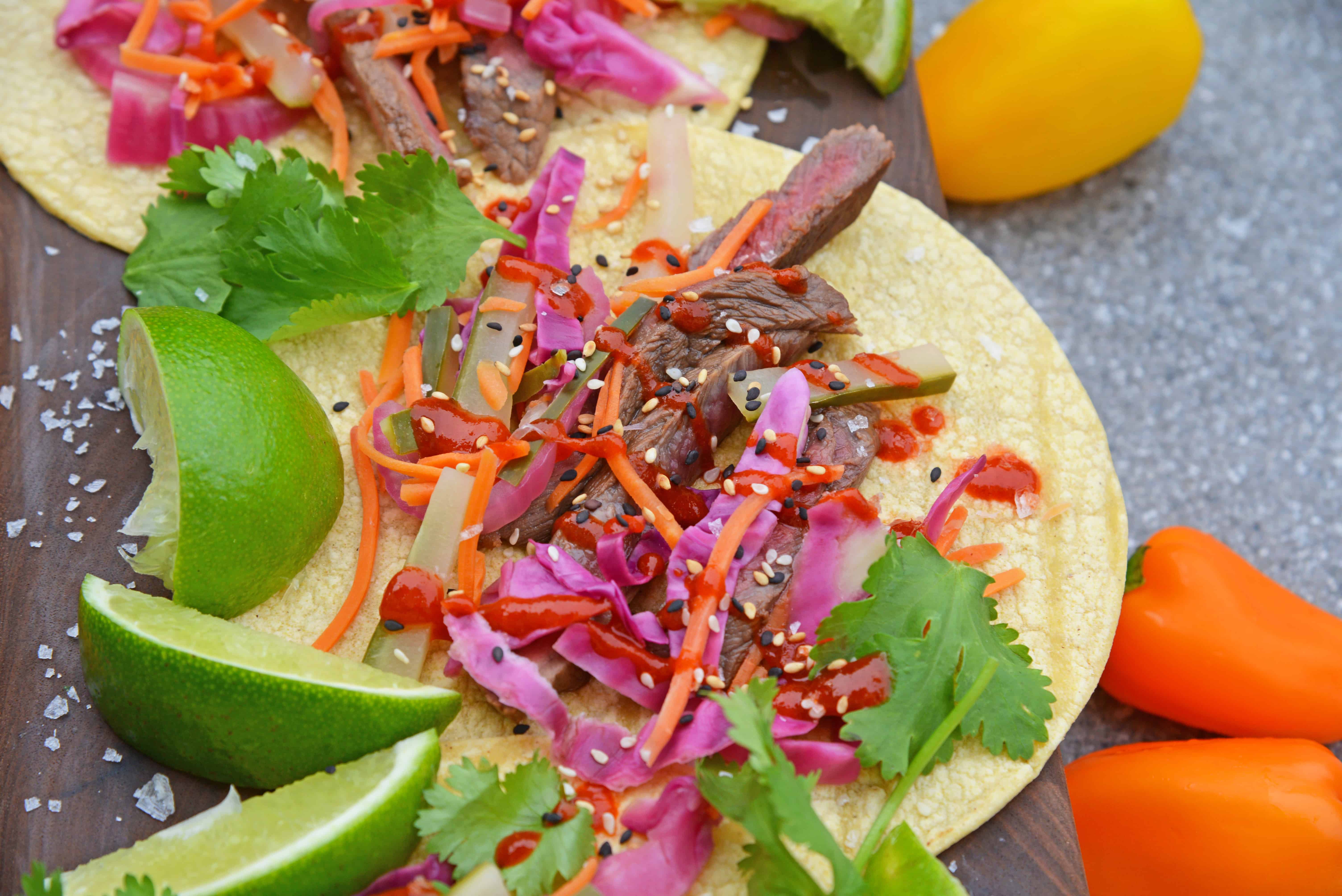 Korean Beef Tacos are stuffed with seasoned bulgogi beef, fresh veggies, and spicy sauce! These are the best Korean tacos you will ever eat! Easy and tasty! #Koreanbeeftacos #bulgogitacos www.savoryexperiments.com