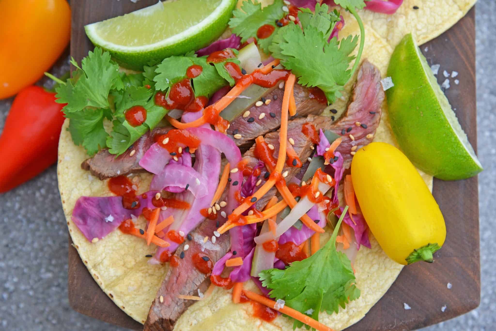 Korean Beef Tacos are stuffed with seasoned bulgogi beef, fresh veggies, and spicy sauce! These are the best Korean tacos you will ever eat! Easy and tasty! #Koreanbeeftacos #bulgogitacos www.savoryexperiments.com