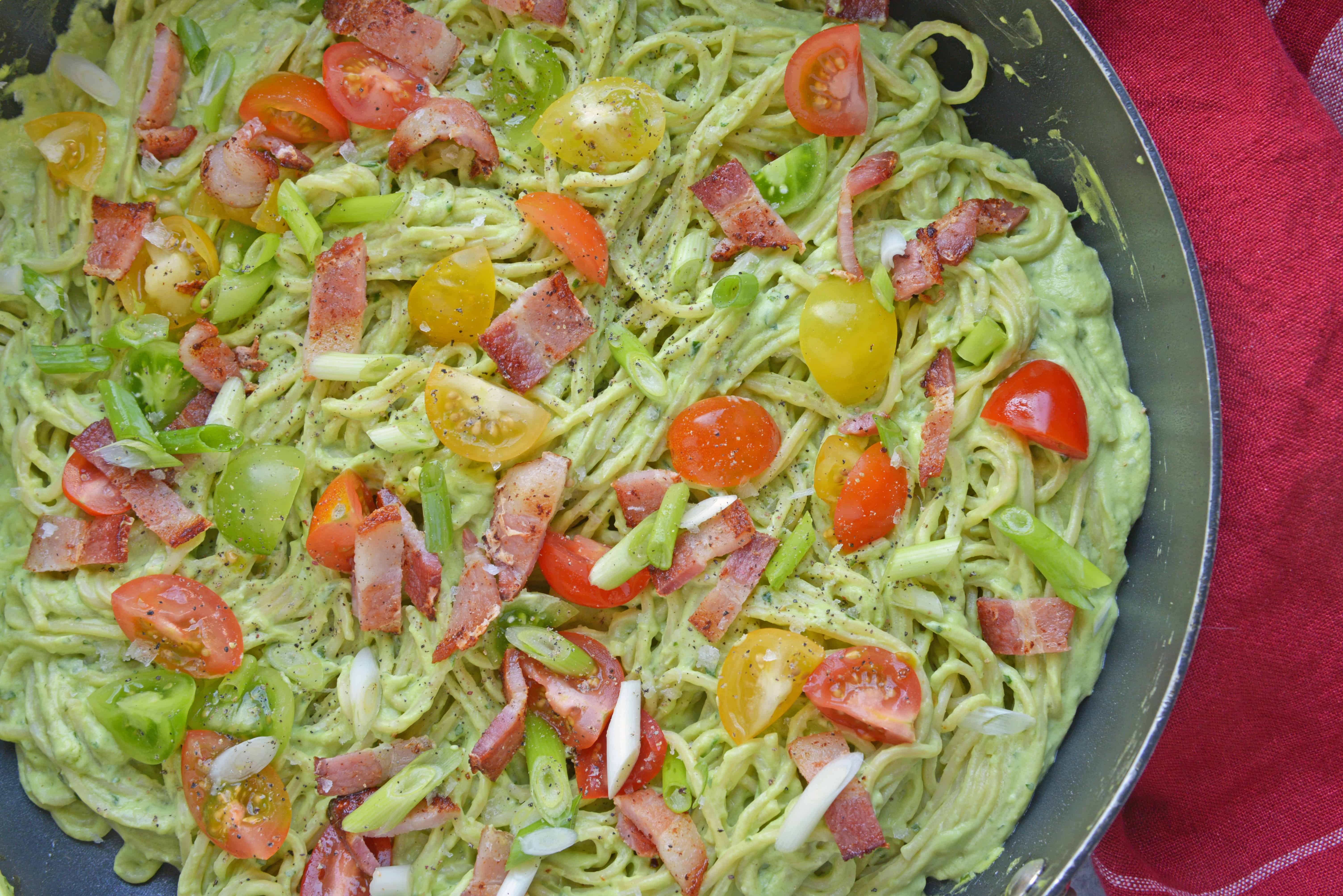 Healthy Creamy Avocado Pasta Sauce is a great alternative to traditional Alfredo sauce. Avocados, thick Greek yogurt, lemon juice, tomatoes and scallions make this wildly popular dish a favorite. Bacon optional! #avocadocreamsauce #creamyavocadopastasauce www.savoryexperiments.com 