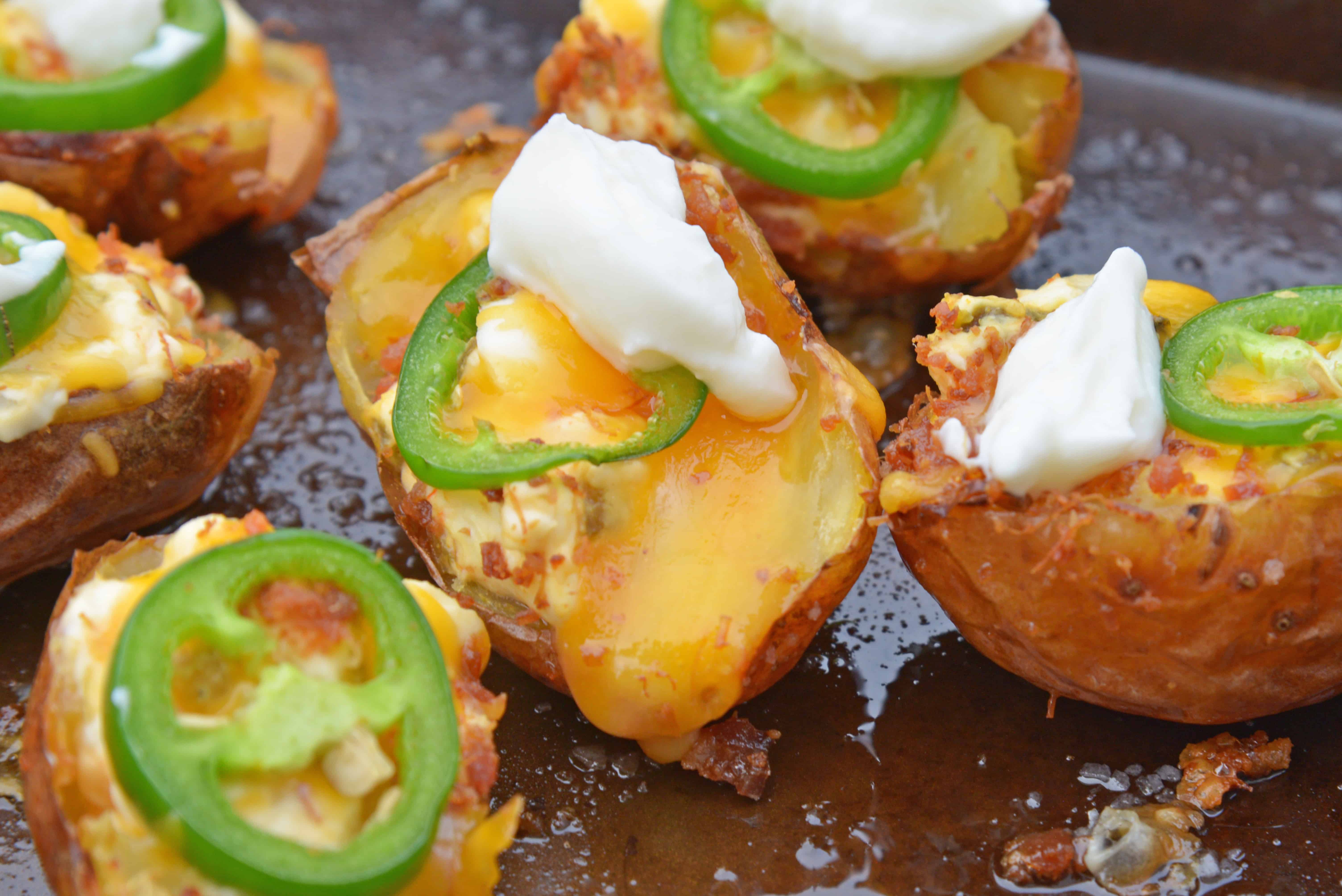 Jalapeno Popper Potato Skins are bite-sized potatoes filled with 3 types of cheese, fresh jalapenos, bacon and cooled off with sour cream. Perfect for a snack or party appetizer! #potatoskins #jalapenopoppers www.savoryexperiments.com