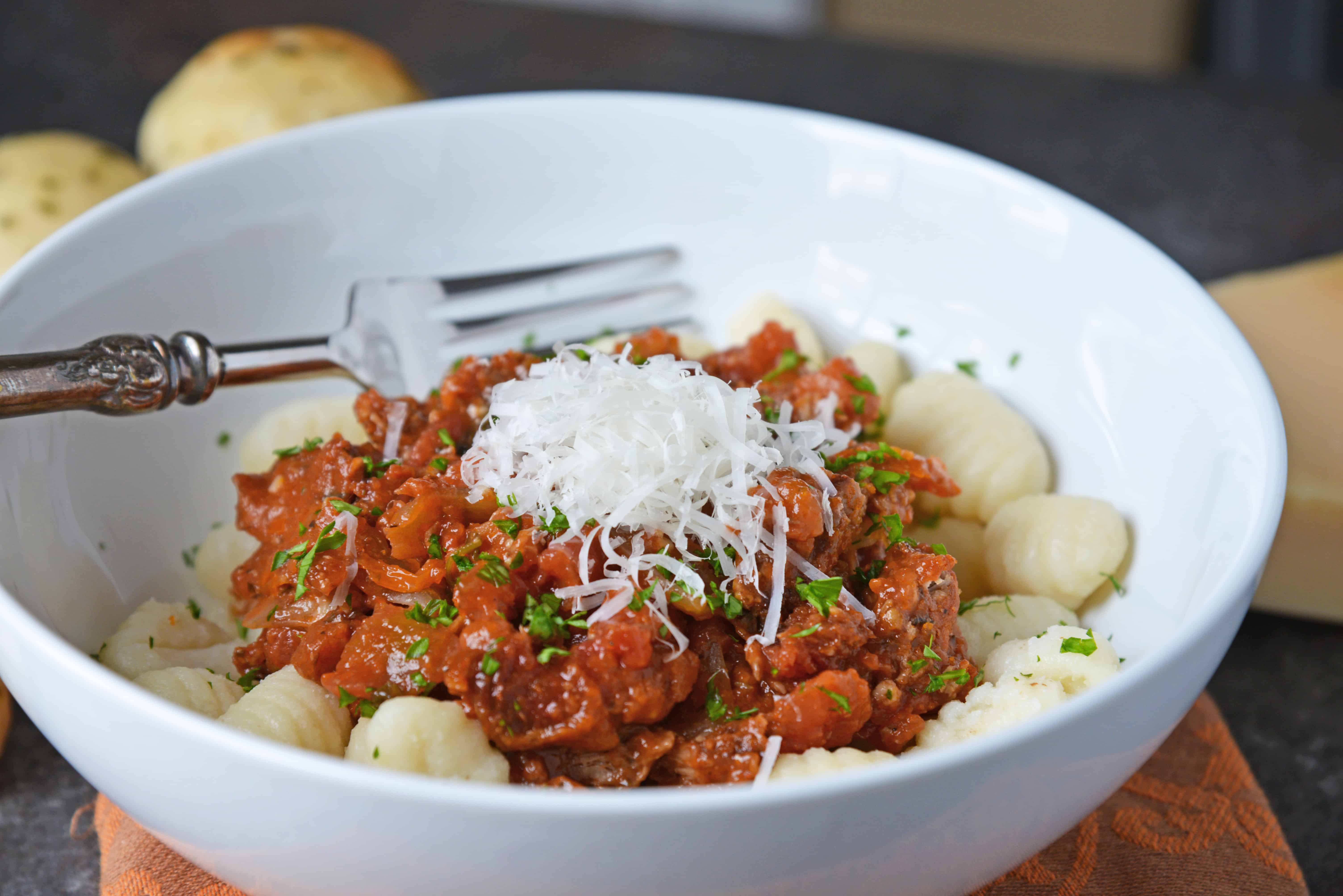 Slow Cooker Ragu uses a blend of 7 vegetables with shredded pork and flavorful spices to make a hearty and delicious ragu sauce. Serve over pasta. Also freezer friendly! #slowcookerragu #slowcookerrecipes www.savoryexperiments.com