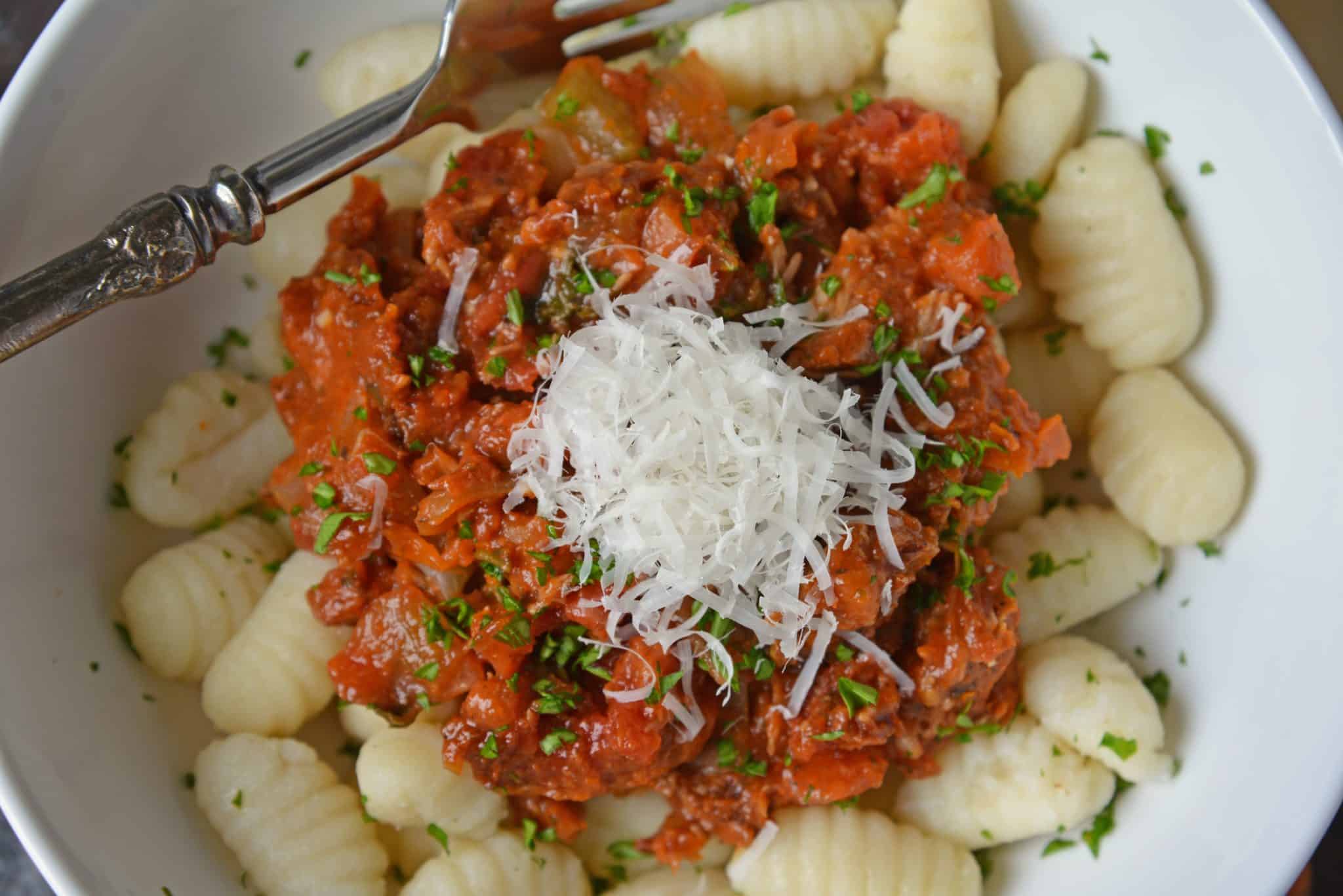 Slow Cooker Ragu uses a blend of 7 vegetables with shredded pork and flavorful spices to make a hearty and delicious ragu sauce. Serve over pasta. Also freezer friendly! #slowcookerragu #slowcookerrecipes www.savoryexperiments.com