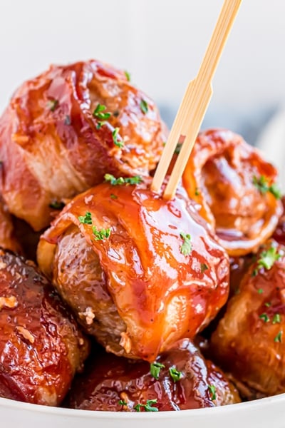 bowl of bacon wrapped meatballs with a wooden toothpick