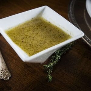 Dijon Lime Salad Dressing in a white bowl with a spoon next to it