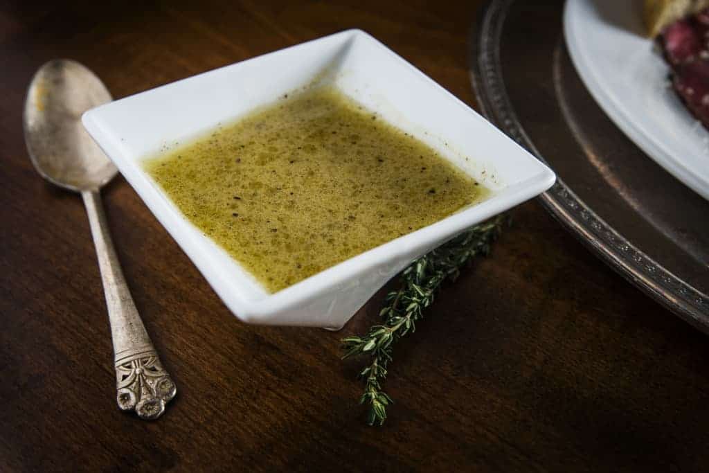 Dijon Lime Salad Dressing in a white bowl with a spoon next to it