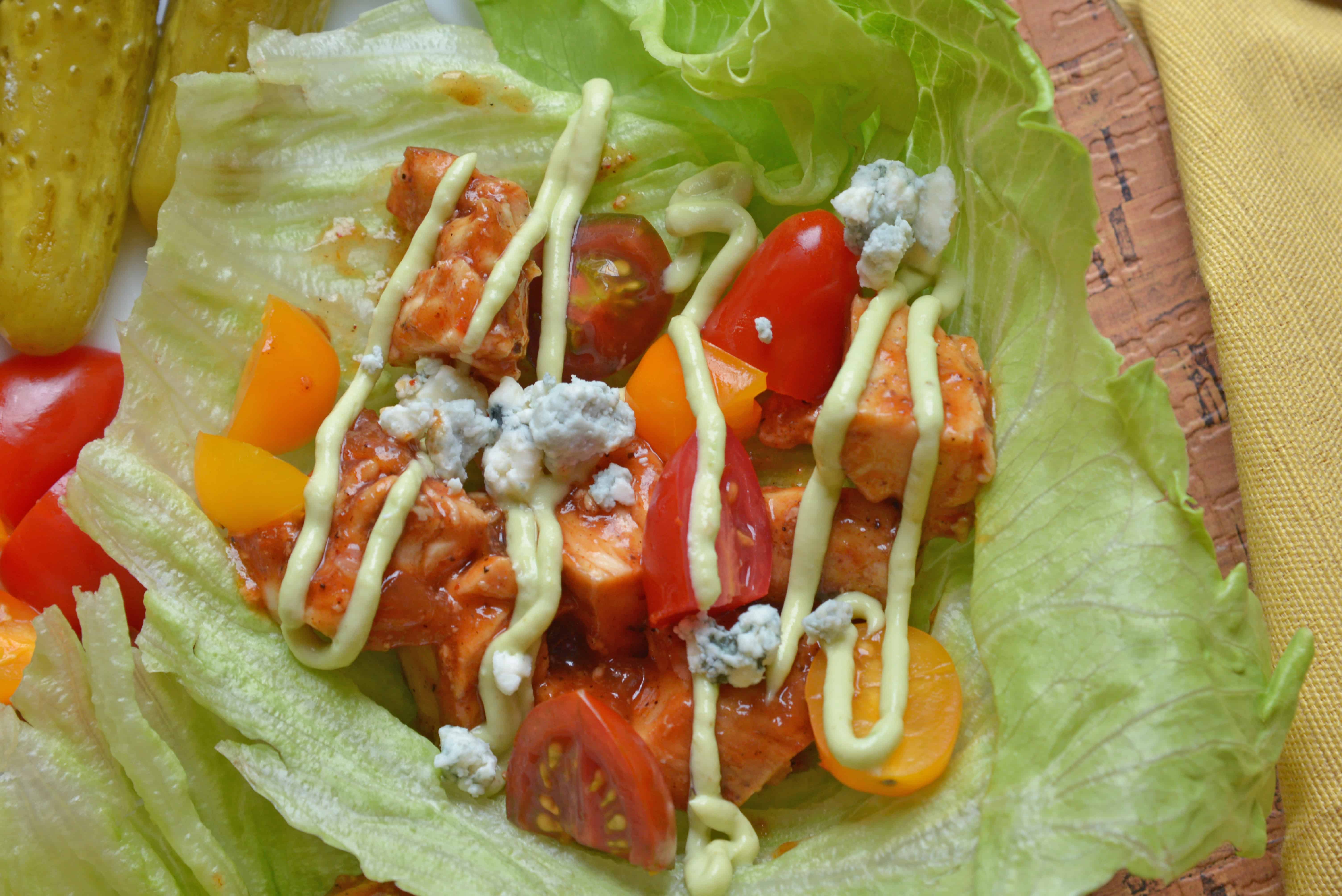 BBQ Chicken Lettuce Wraps use seasoned chicken with your favorite BBQ sauce and wrap them in crispy lettuce with juicy tomatoes, blue cheese and cool avocado dressing. #lettucewraps www.savoryexperiments.com 