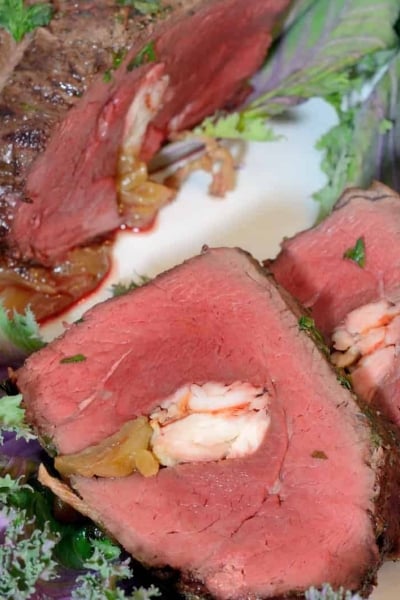 Crab Stuffed Beef Tenderloin takes a tenderloin and fills the center with buttered crab and caramelized onions, then baked to perfection with a black pepper bark. #beeftenderloinrecipe www.savoryexperiments.com