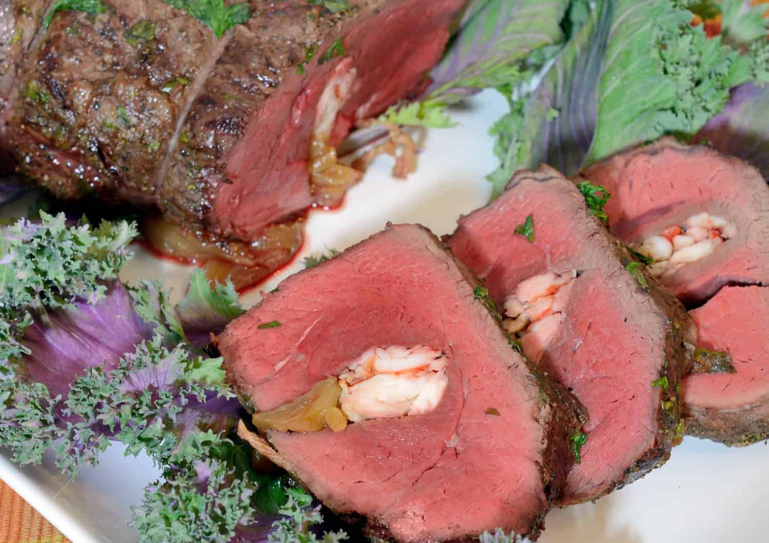 Crab Stuffed Beef Tenderloin takes a tenderloin and fills the center with buttered crab and caramelized onions, then baked to perfection with a black pepper bark. #beeftenderloinrecipe www.savoryexperiments.com 