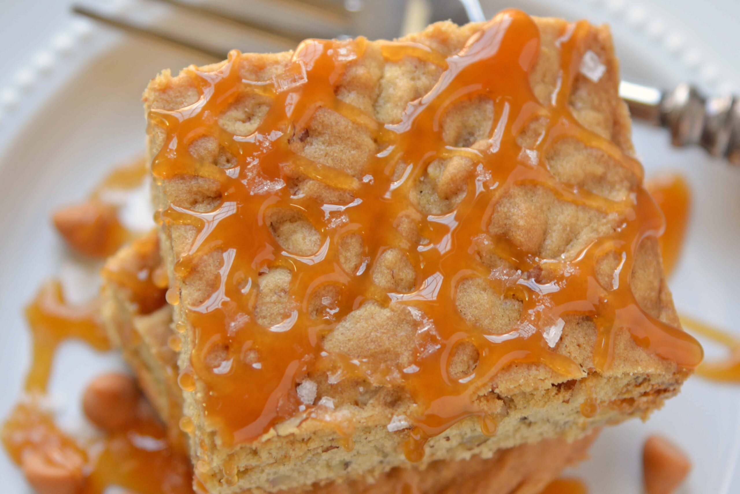 Soft Butterscotch Blondies are soft brown butter brownies loaded with butterscotch chips and drizzled with salted caramel sauce. #brownbutterbrownies #butterscotchbrownies www.savoryexperiments.com