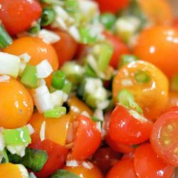 Winter Tomato Salad uses multi-colored cherry tomatoes, lots of garlic, good olive oil and basil to make a tasty side dish recipe perfect for the winter months. #tomatosalad #tomatosidedishes www.savoryexperiments.com