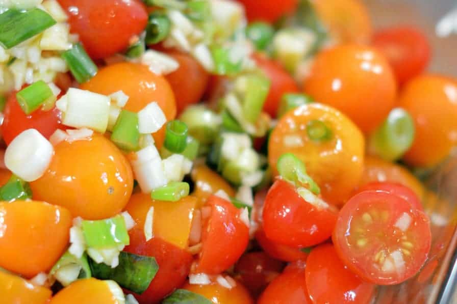 Winter Tomato Salad uses multi-colored cherry tomatoes, lots of garlic, good olive oil and basil to make a tasty side dish recipe perfect for the winter months. #tomatosalad #tomatosidedishes www.savoryexperiments.com 