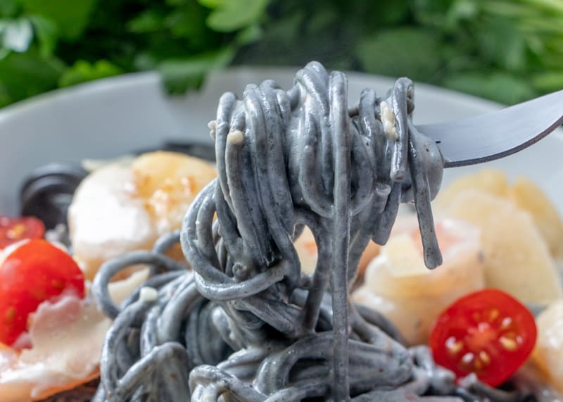 Black pasta twirling on a fork