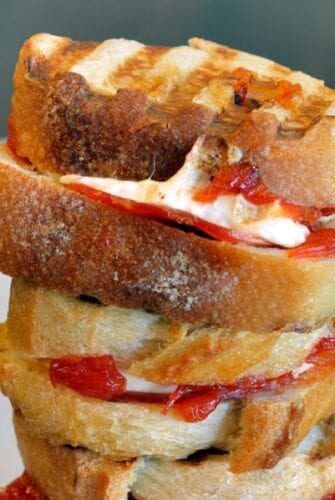 Cheesy Pizza Sandwiches are mini, slider-size grilled cheese sandwiches with mozzarella cheese, tomato jam and pepperoni. Kid friendly and great for parties! #pizzasandwiches www.savoryexperiments.com
