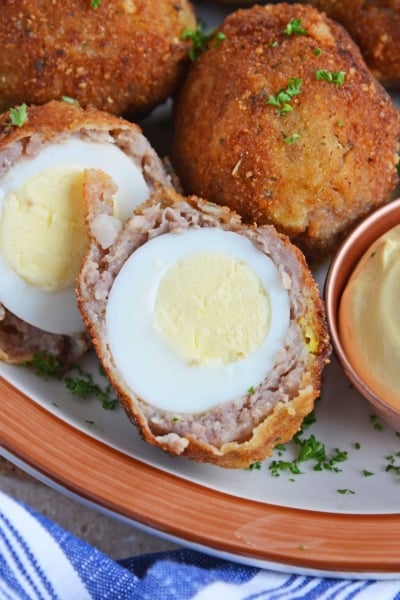 Scotch Eggs on a platter, one cut in half