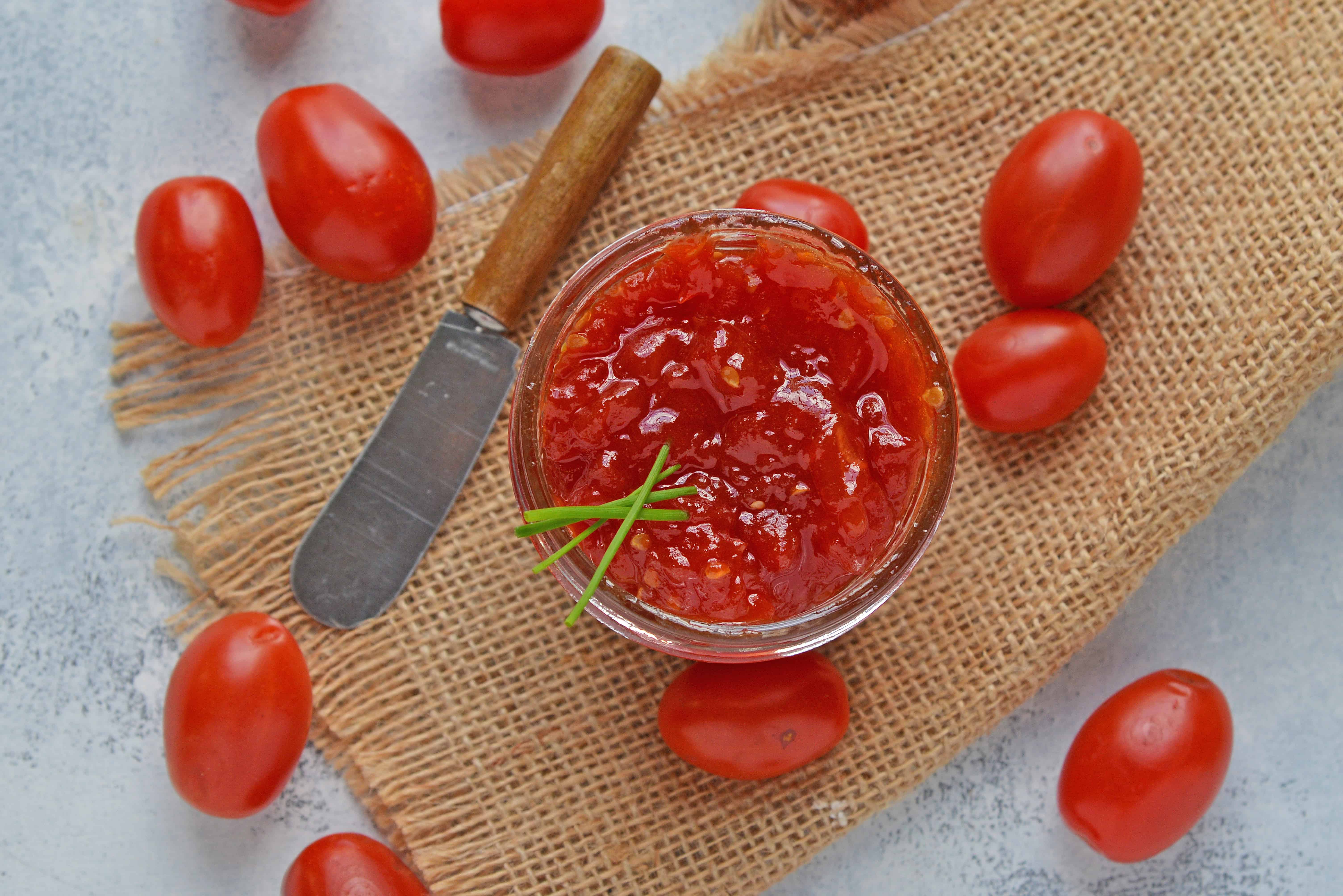 Tangy and sweet, tomato jam is excellent on everything from grilled cheese to deviled eggs, hamburgers and charcuterie boards. #tomatojam #homemadejamrecipe www.savoryexperiments.com 