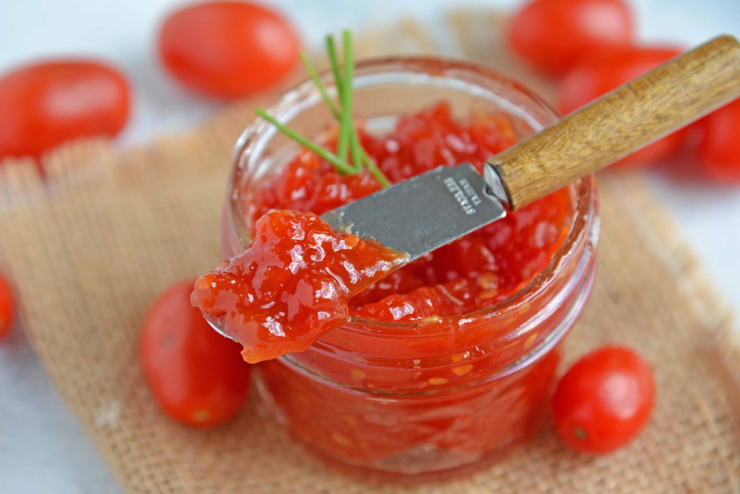 Tangy and sweet, tomato jam is excellent on everything from grilled cheese to deviled eggs, hamburgers and charcuterie boards. #tomatojam #homemadejamrecipe www.savoryexperiments.com